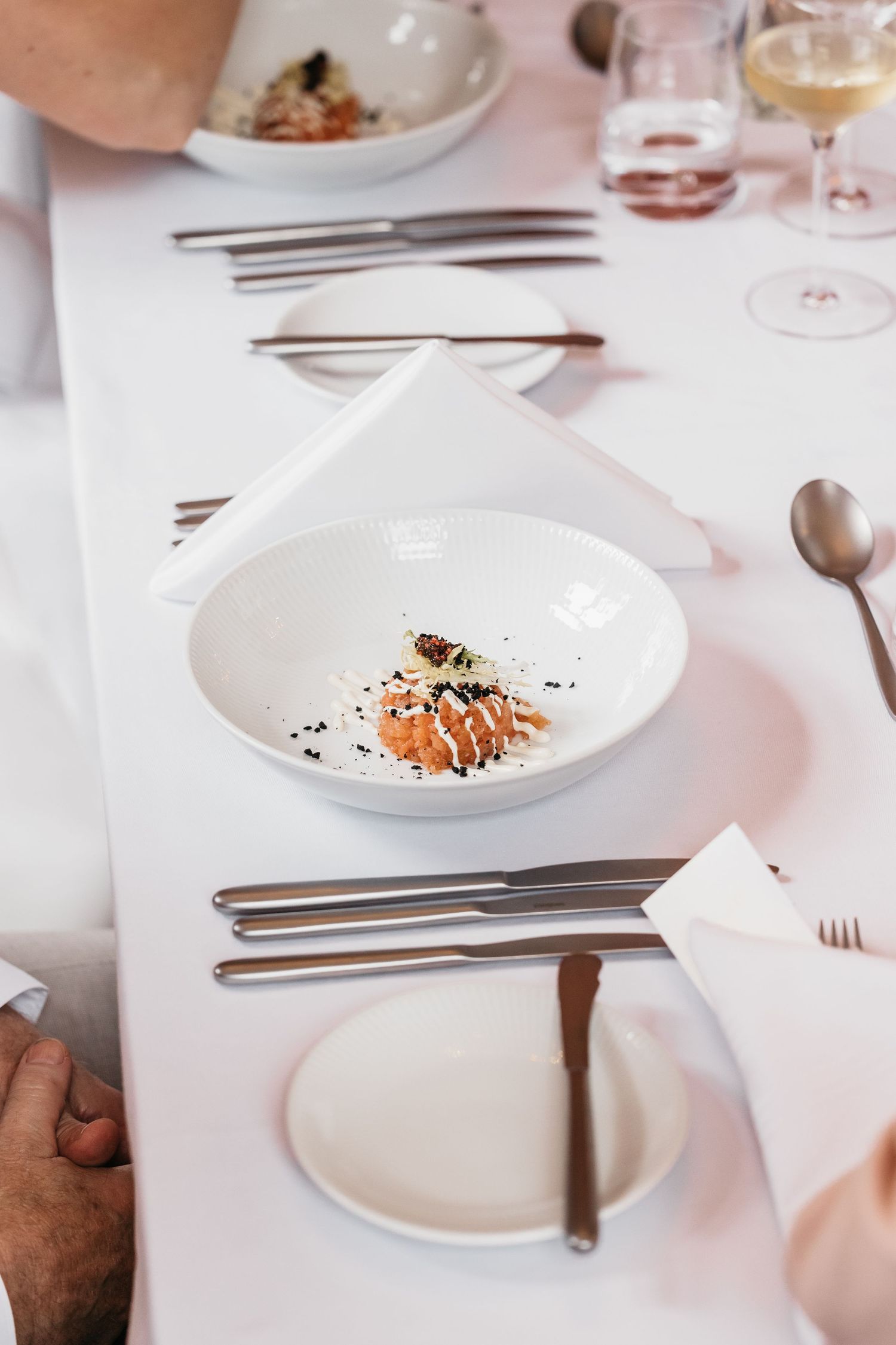 Elegant wedding reception starter dish served in white bowl on formal table setting.