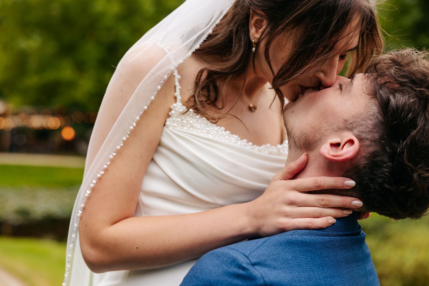 Close-up of bride and groom sharing a passionate kiss on their wedding day.