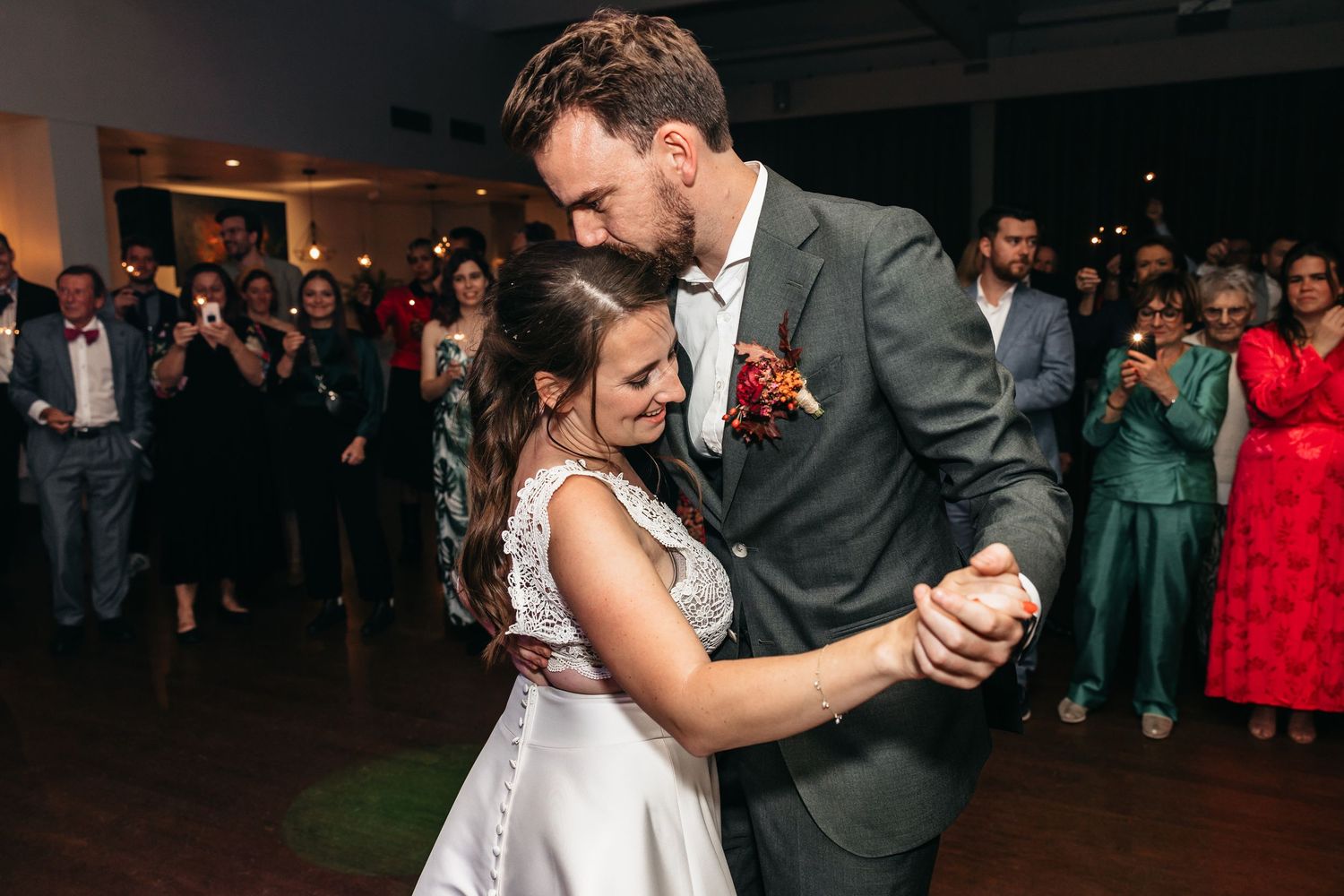 Couple shares intimate first dance moment with bride in lace wedding gown.