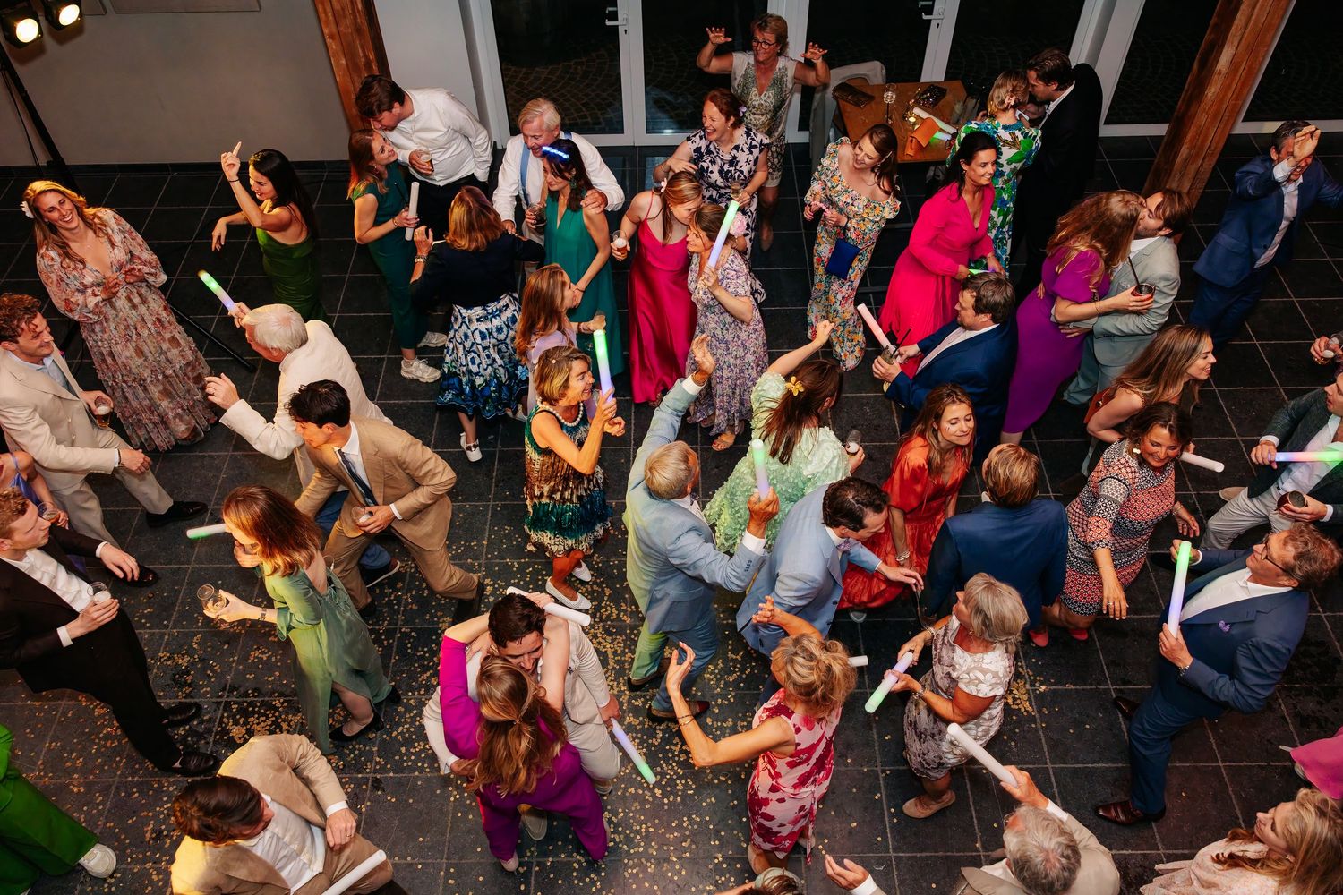Aerial view of wedding guests dancing together on a crowded dance floor at a reception.