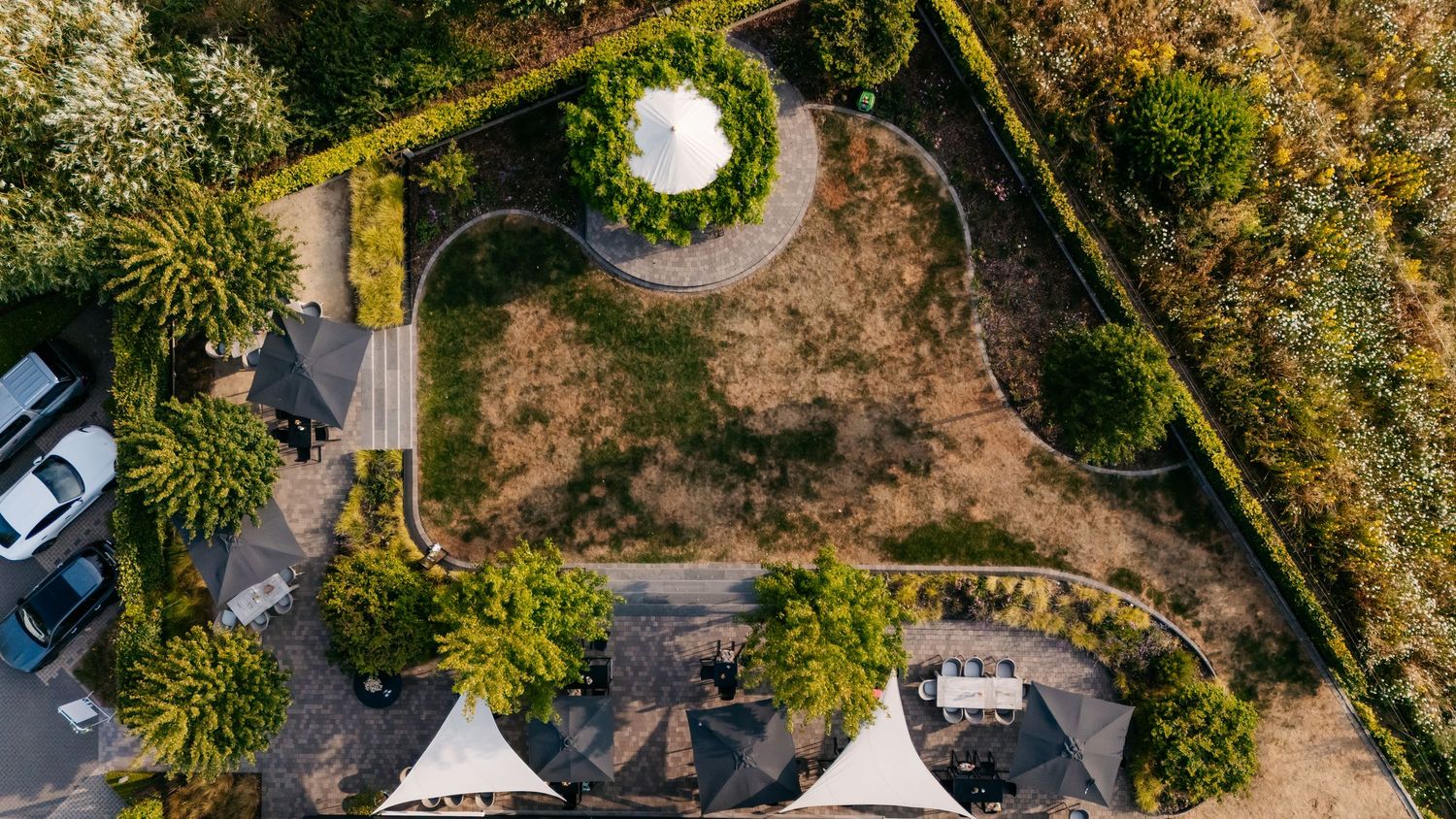 Aerial view of wedding venue grounds with circular garden feature and trees.