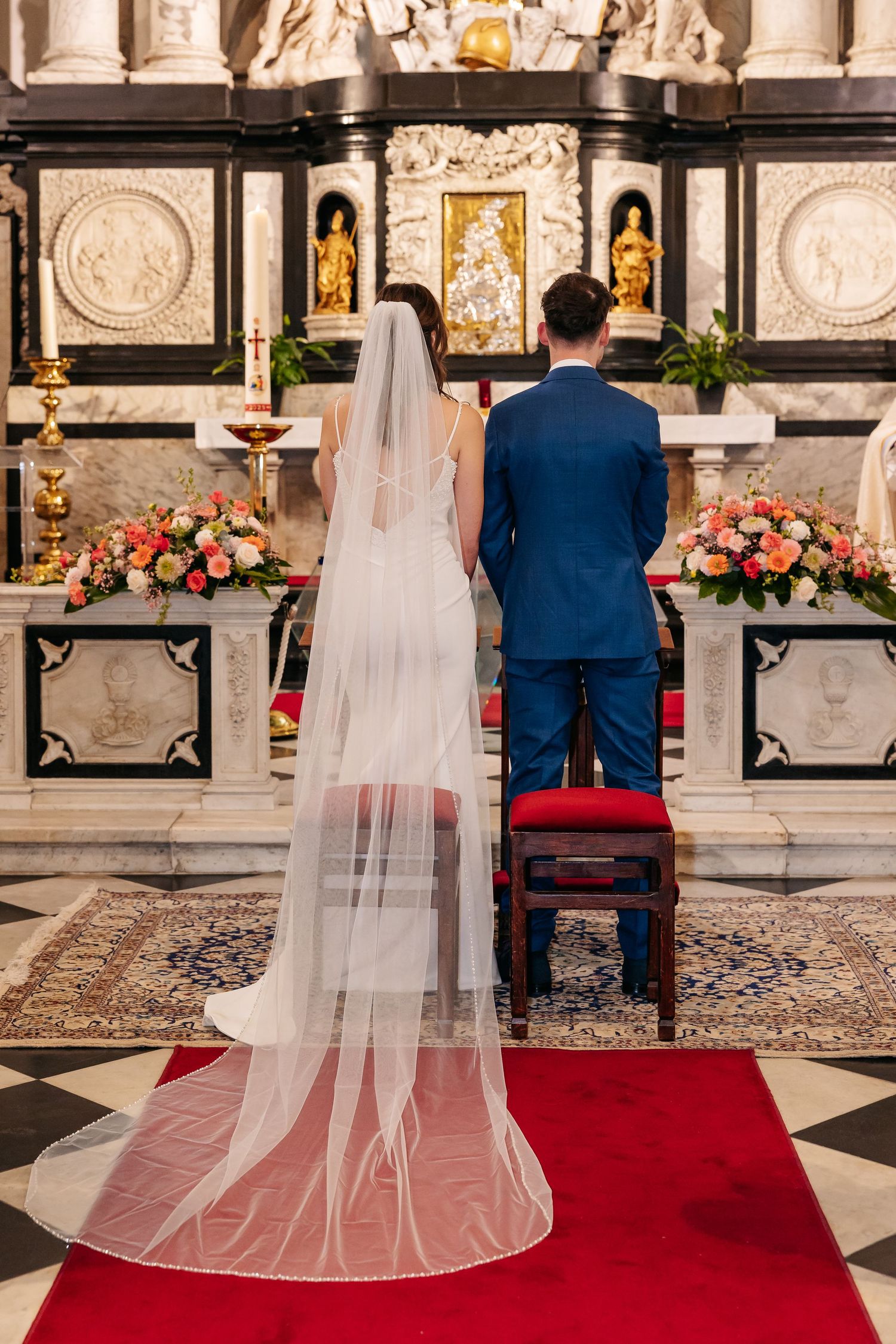 Bride and groom standing at the altar during a traditional Catholic church wedding ceremony.