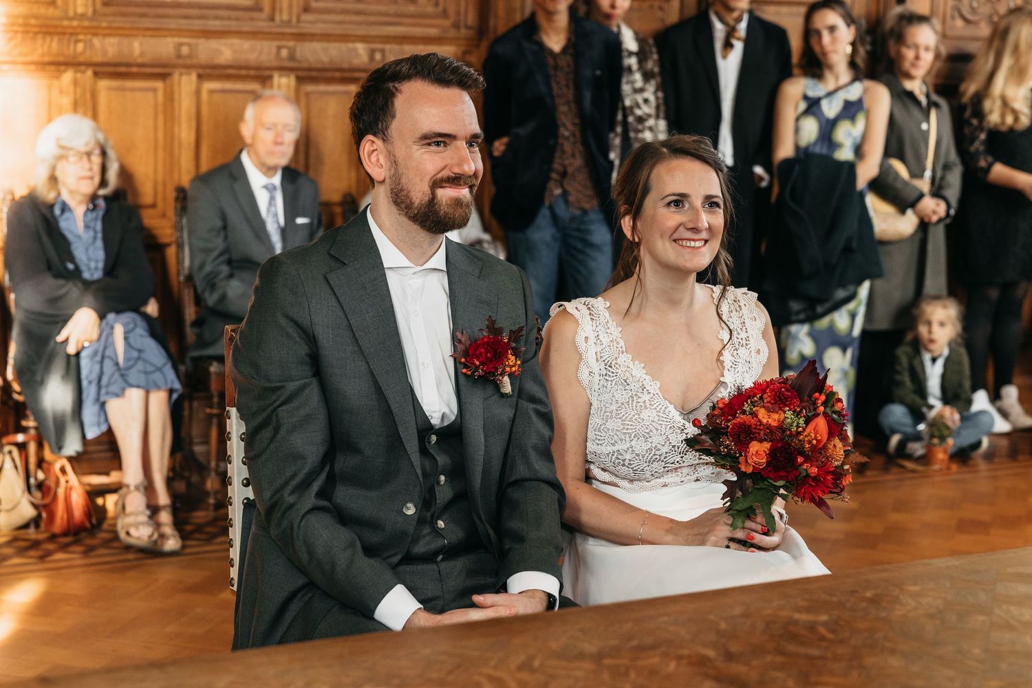 Smiling bride and groom seated together during their wedding ceremony.