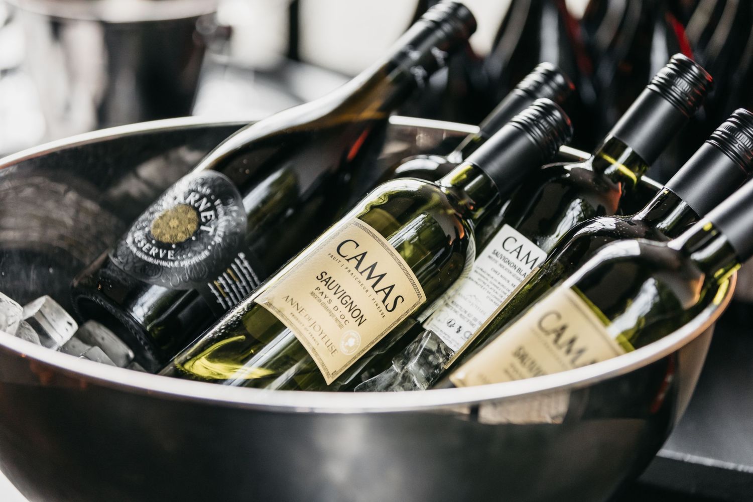 Bottles of Camas Sauvignon blanc and red wine chilling in ice bucket at wedding reception.