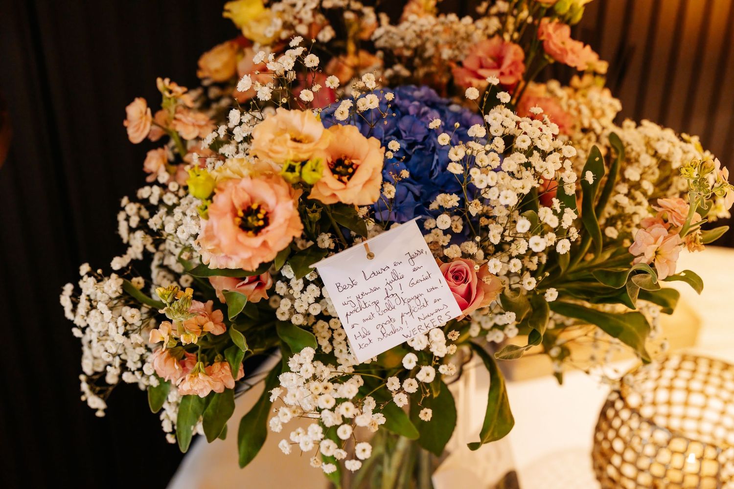 Colorful bridal bouquet with hydrangeas, roses and baby's breath with handwritten note.