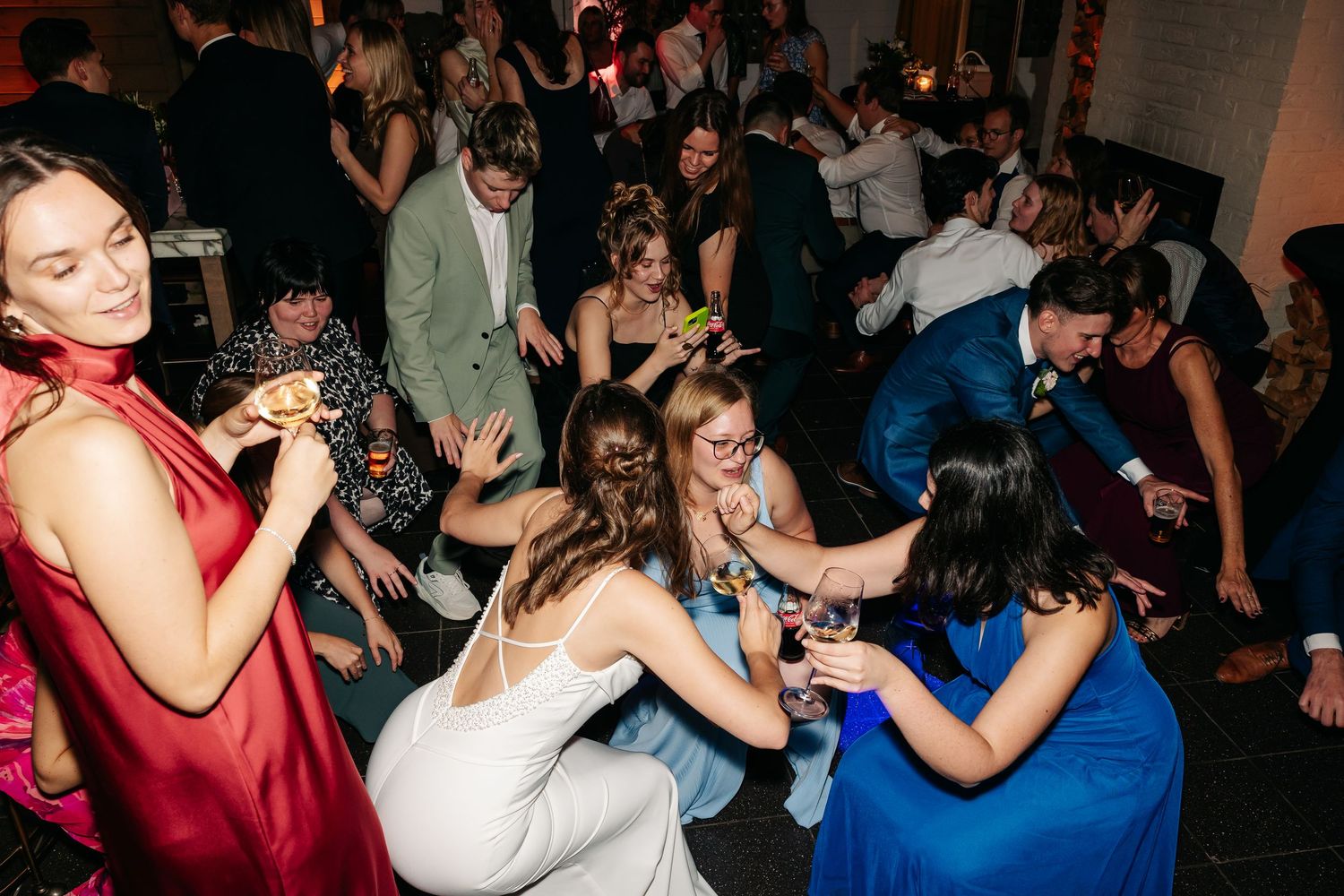 Guests dancing and celebrating at a lively wedding reception party on the dance floor.