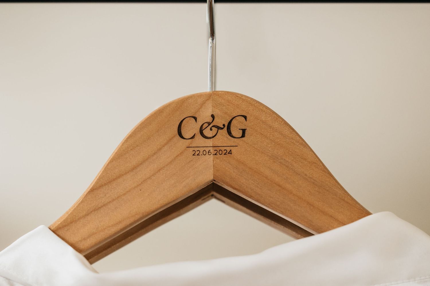 Custom wooden wedding hanger engraved with C&G and date 22.06.2024.