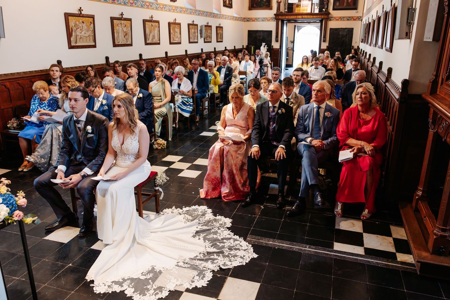 Wide view of bride and groom at altar with full church of wedding guests.