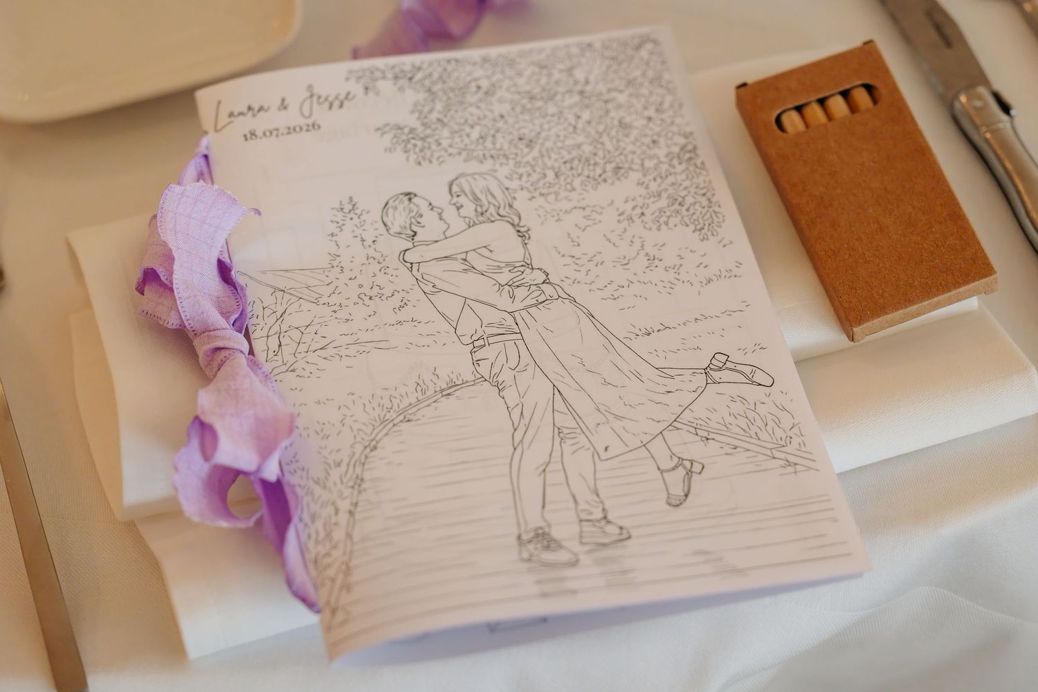 Wedding coloring page featuring a sketch of a couple dancing, with colored pencils in a cork box.
