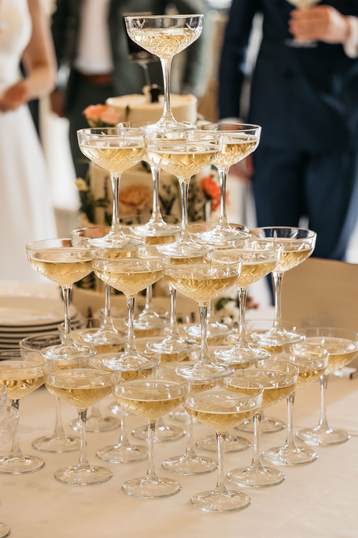 Elegant pyramid tower of champagne glasses filled with sparkling wine at a wedding reception.