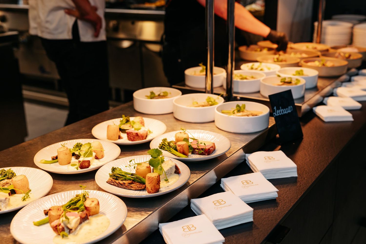 Rows of elegantly plated gourmet appetizers lined up on kitchen counter for wedding reception service.
