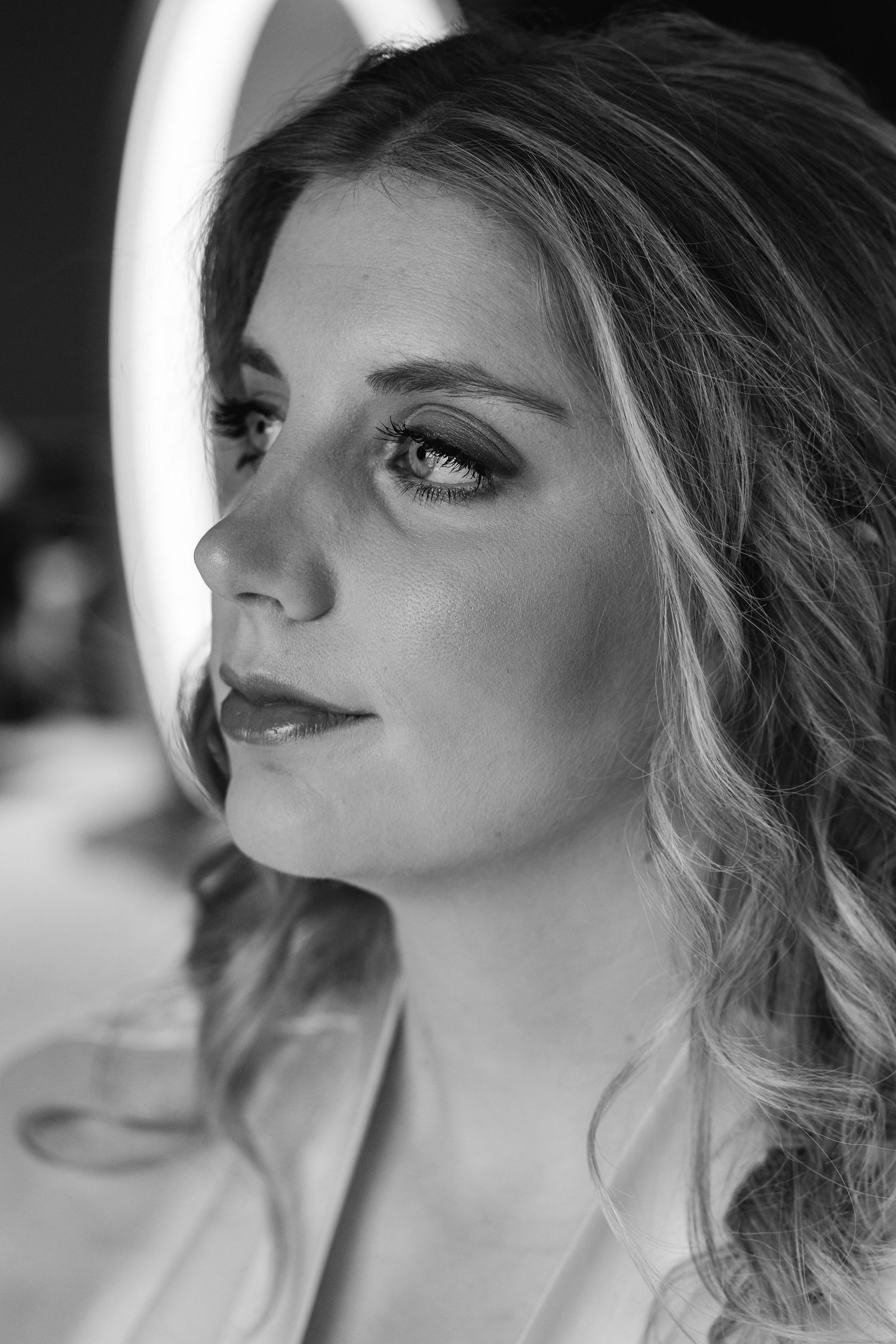 Black and white close-up portrait of a bride with wavy hair and dramatic eye makeup.