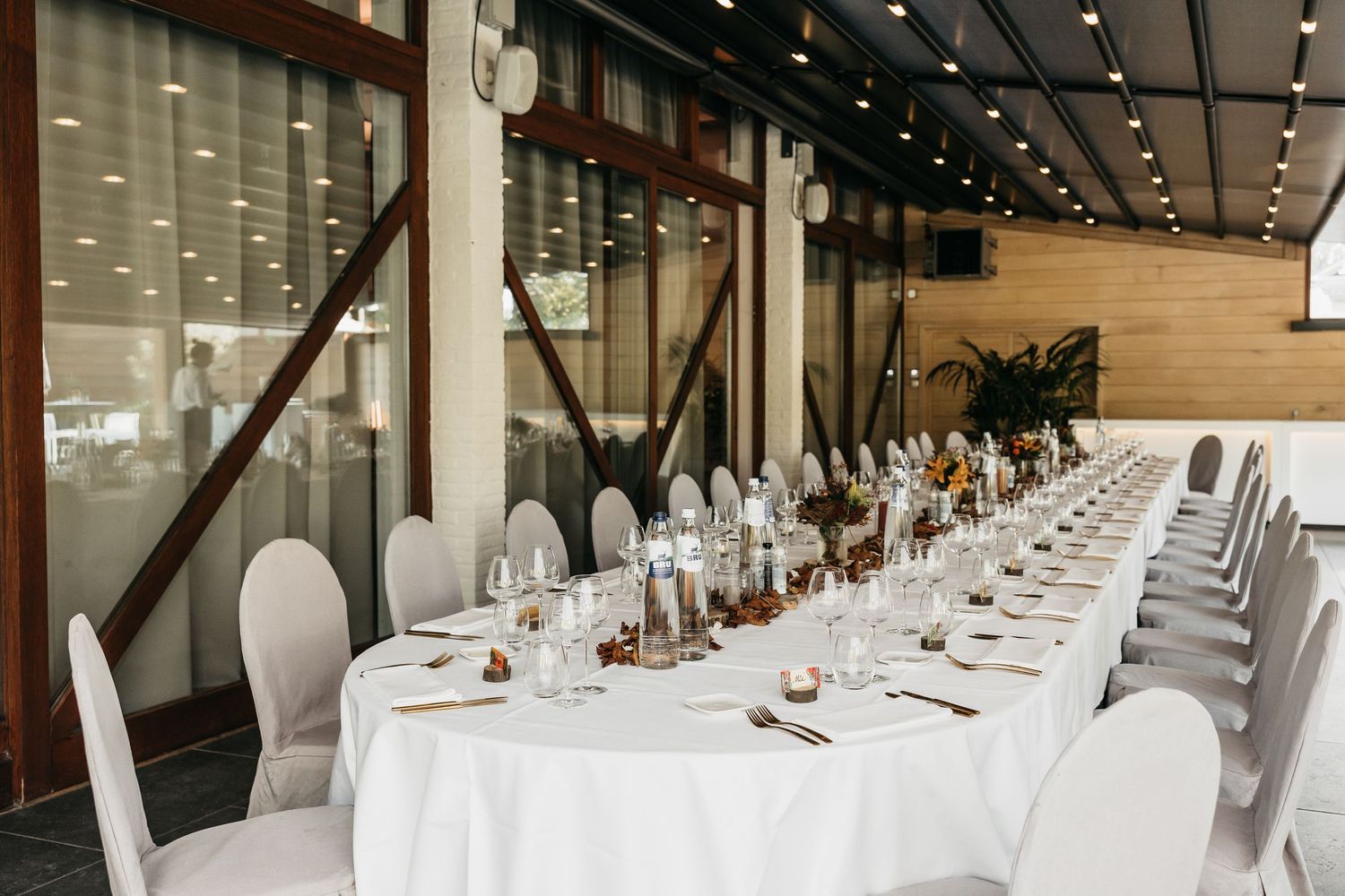 Elegant long wedding reception table with white linens and floral centerpieces.