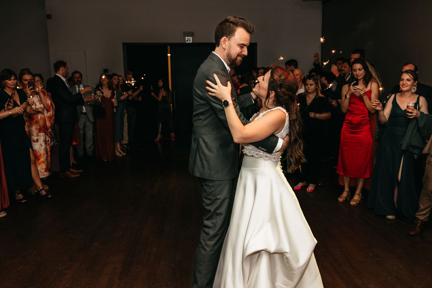Newlyweds sharing a romantic first dance embrace on the wedding reception dance floor.