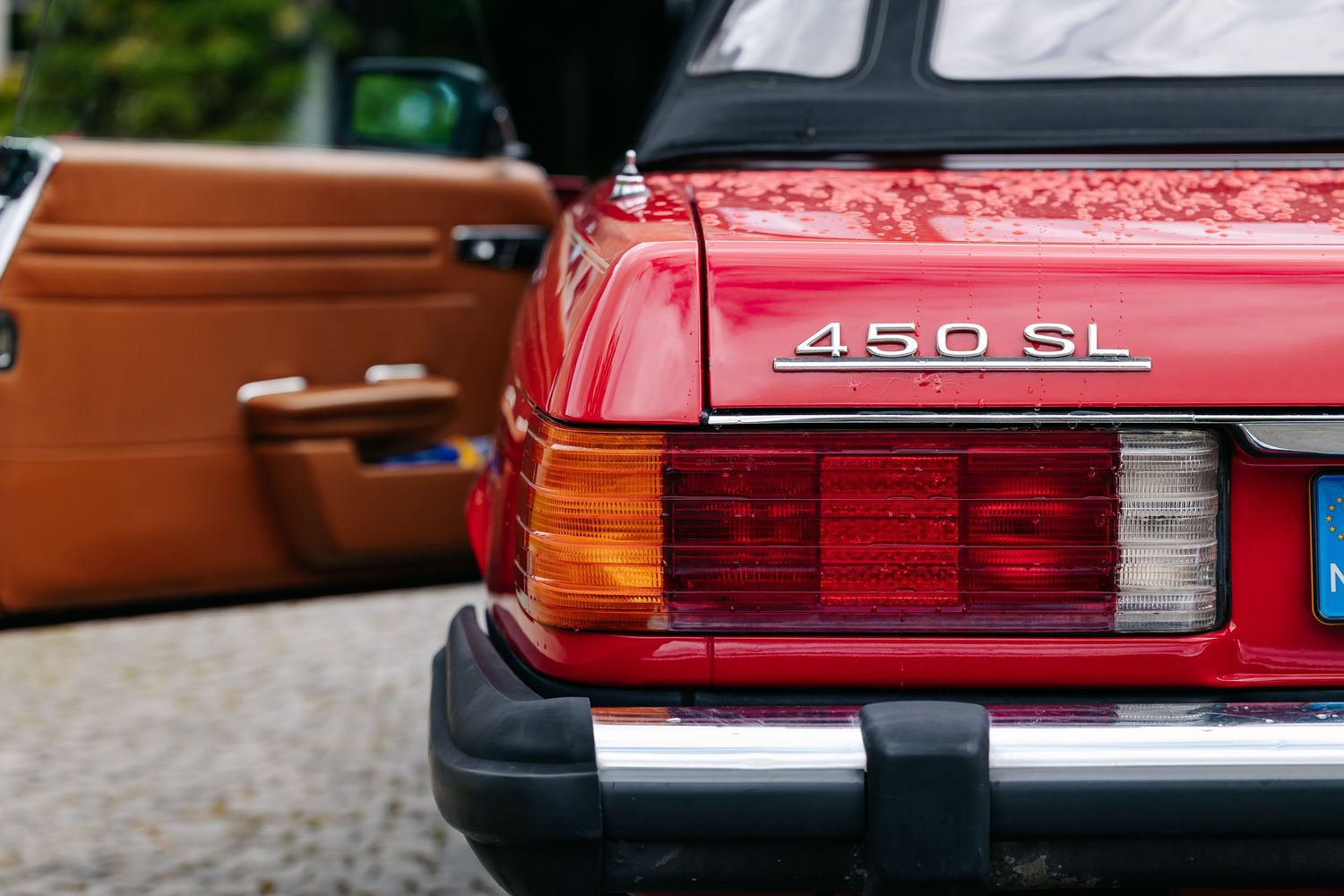 Red Mercedes-Benz 450SL classic sports car rear view showing iconic badge and taillights.