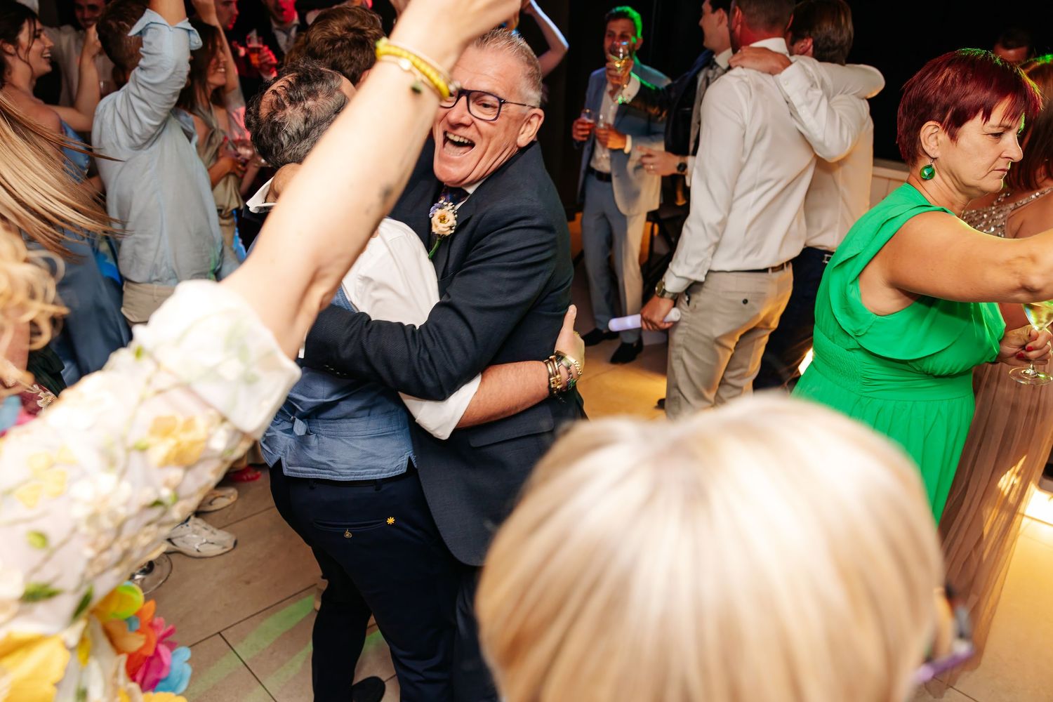 Enthusiastic wedding guest dancing and celebrating on the dance floor at reception party.