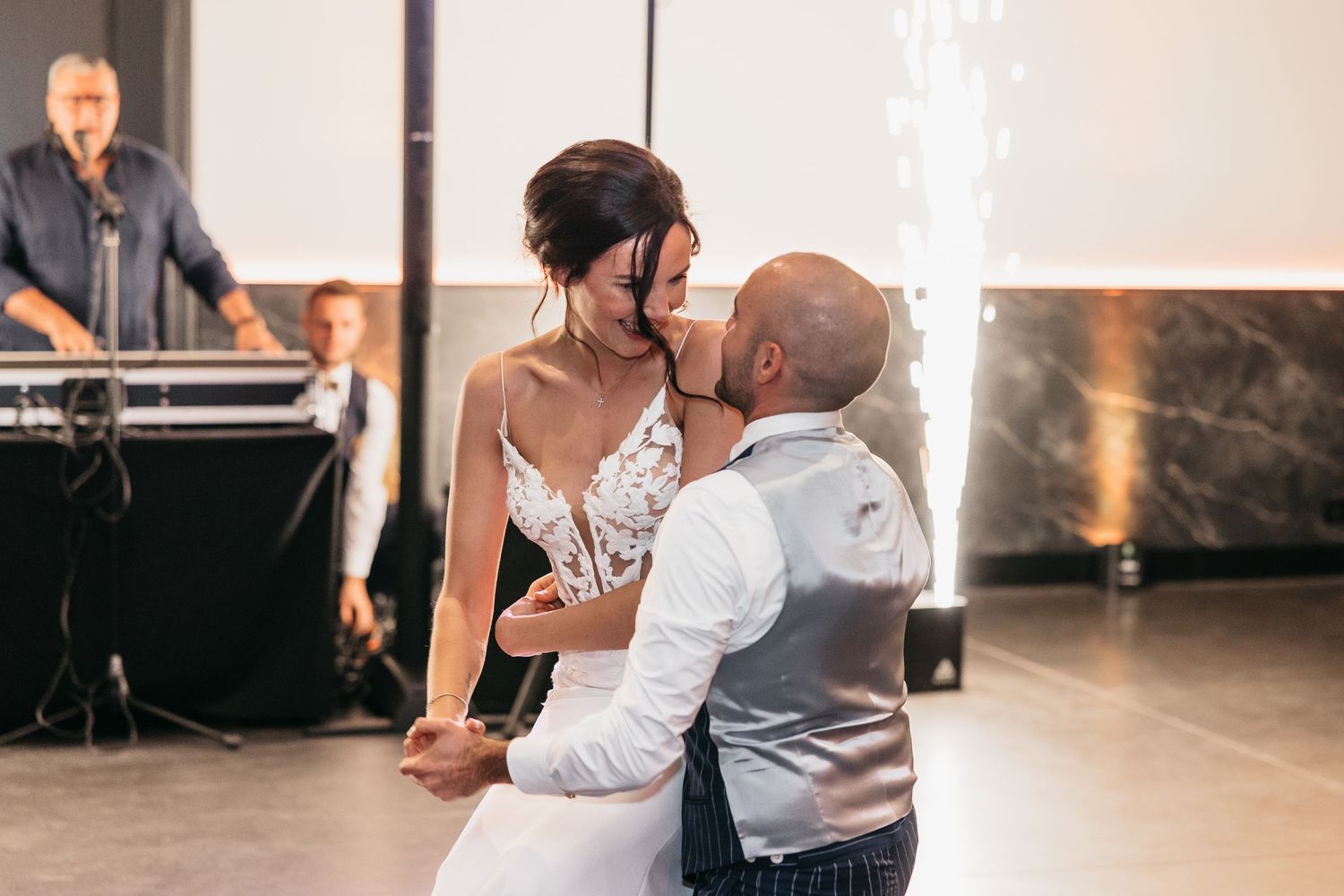 Bride and groom sharing intimate first dance kiss at elegant wedding reception with sparklers.