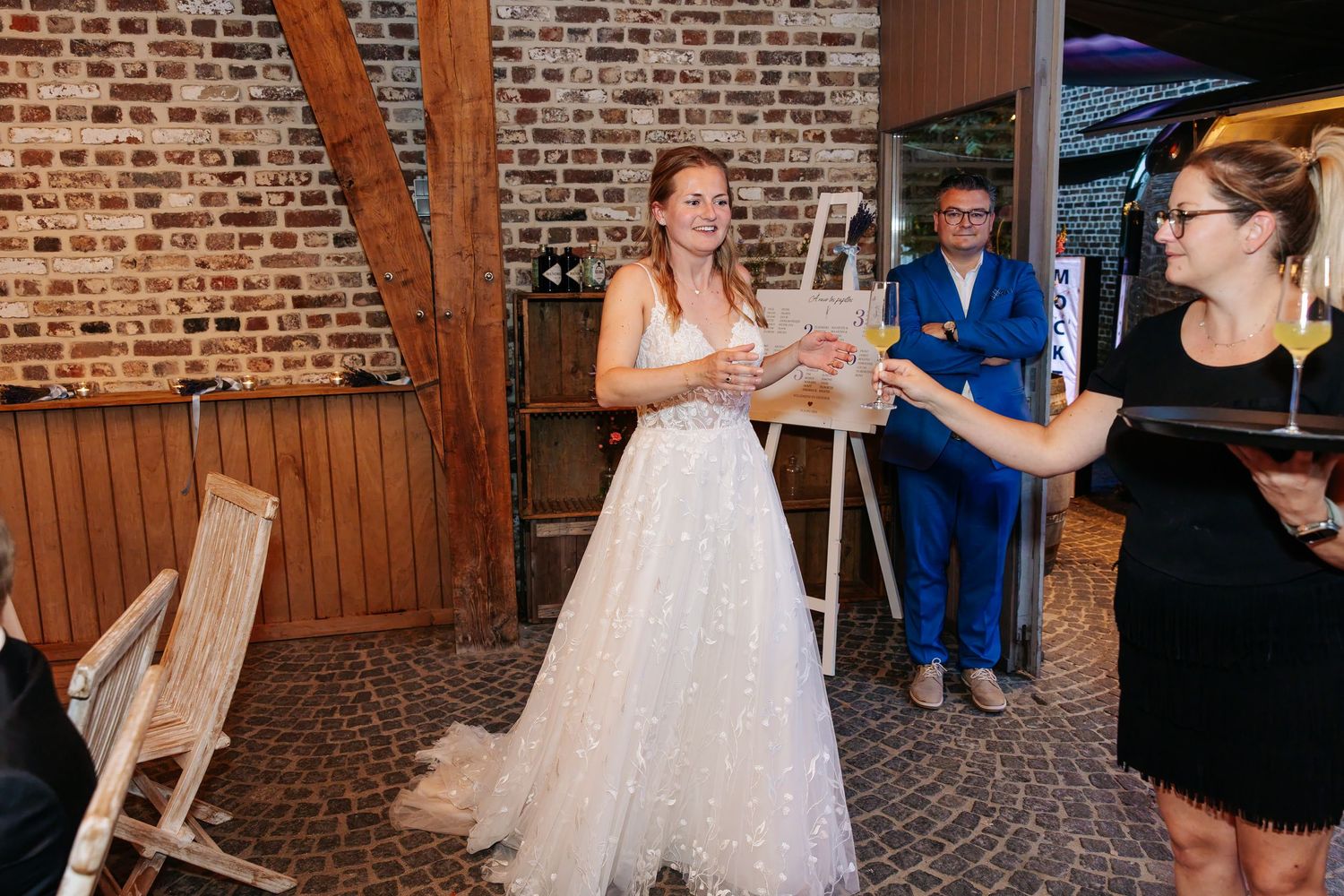 Radiant bride in a sparkly white gown receiving a gift from a guest at the wedding reception.
