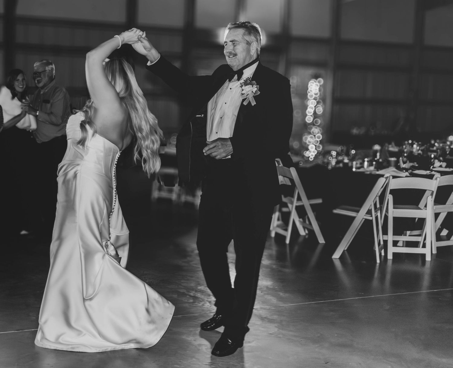 Black-and-white photo of the bride and father dancing at their reception.