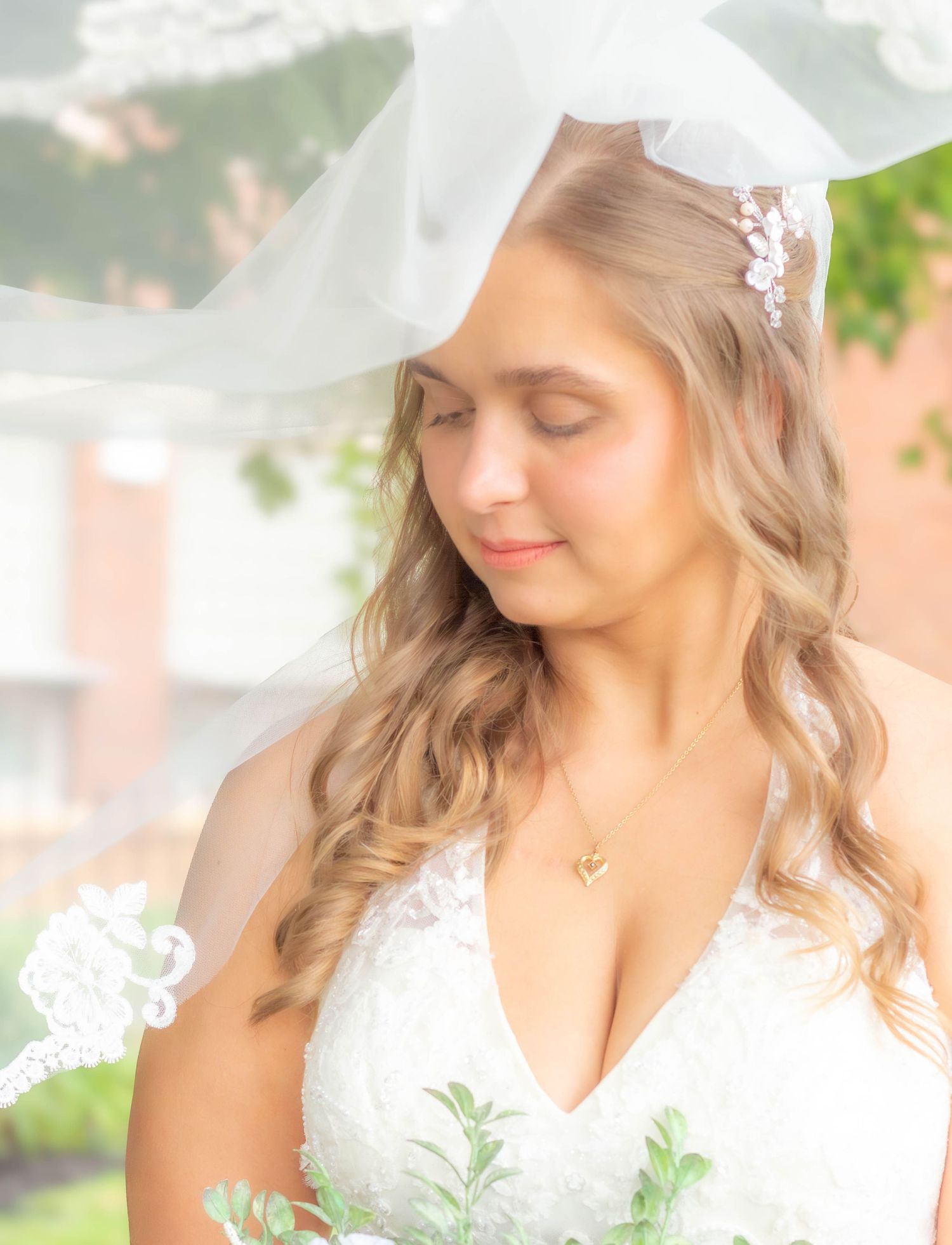Bridal portrait of a bride wearing her veil outdoors.