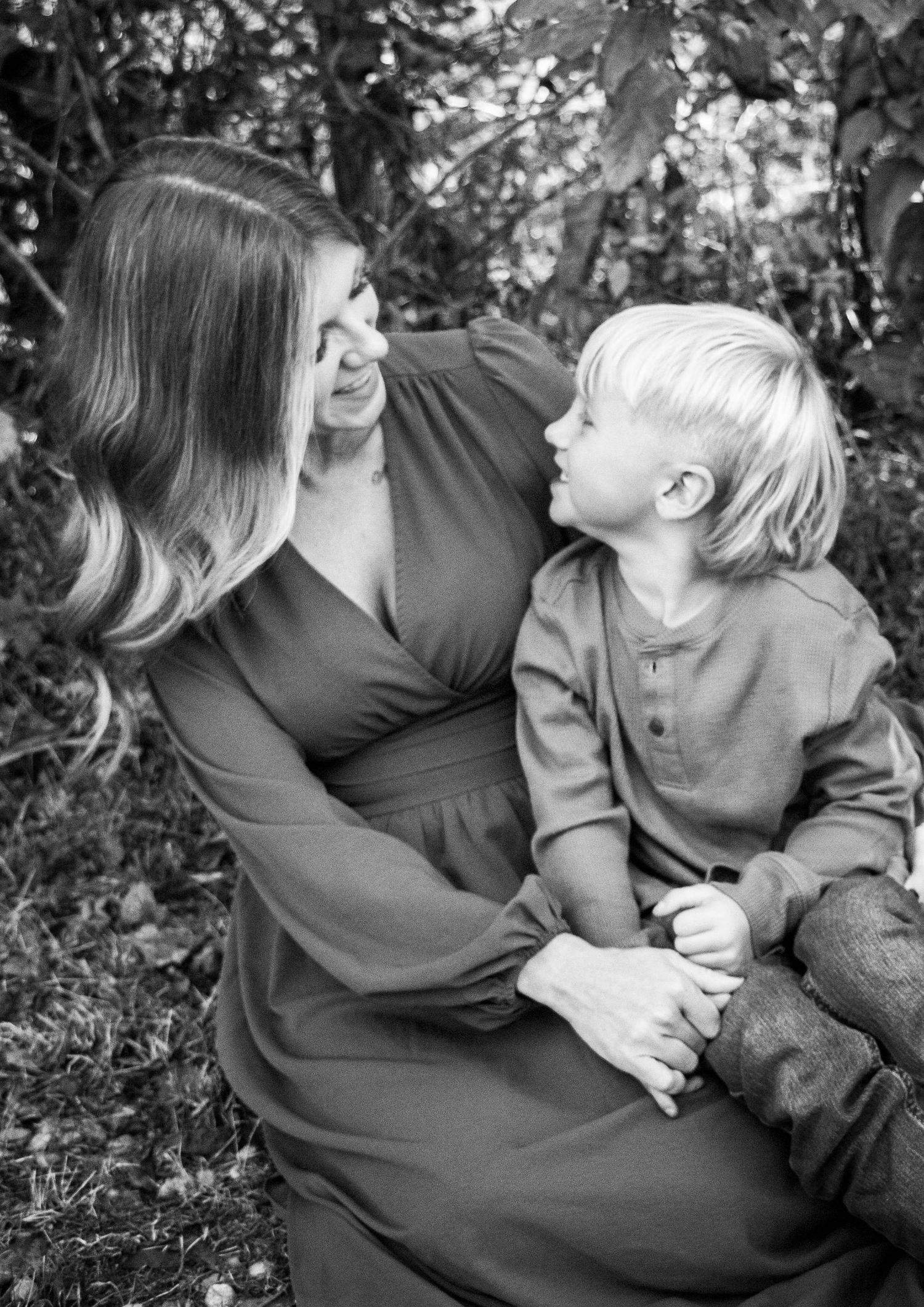 Mother cuddling her young son during a close-up family portrait in black and white