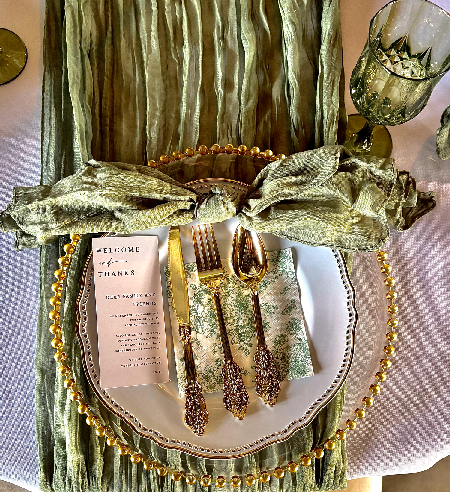 Elegant wedding place setting with gold details, personalized menu and decorative napkin.