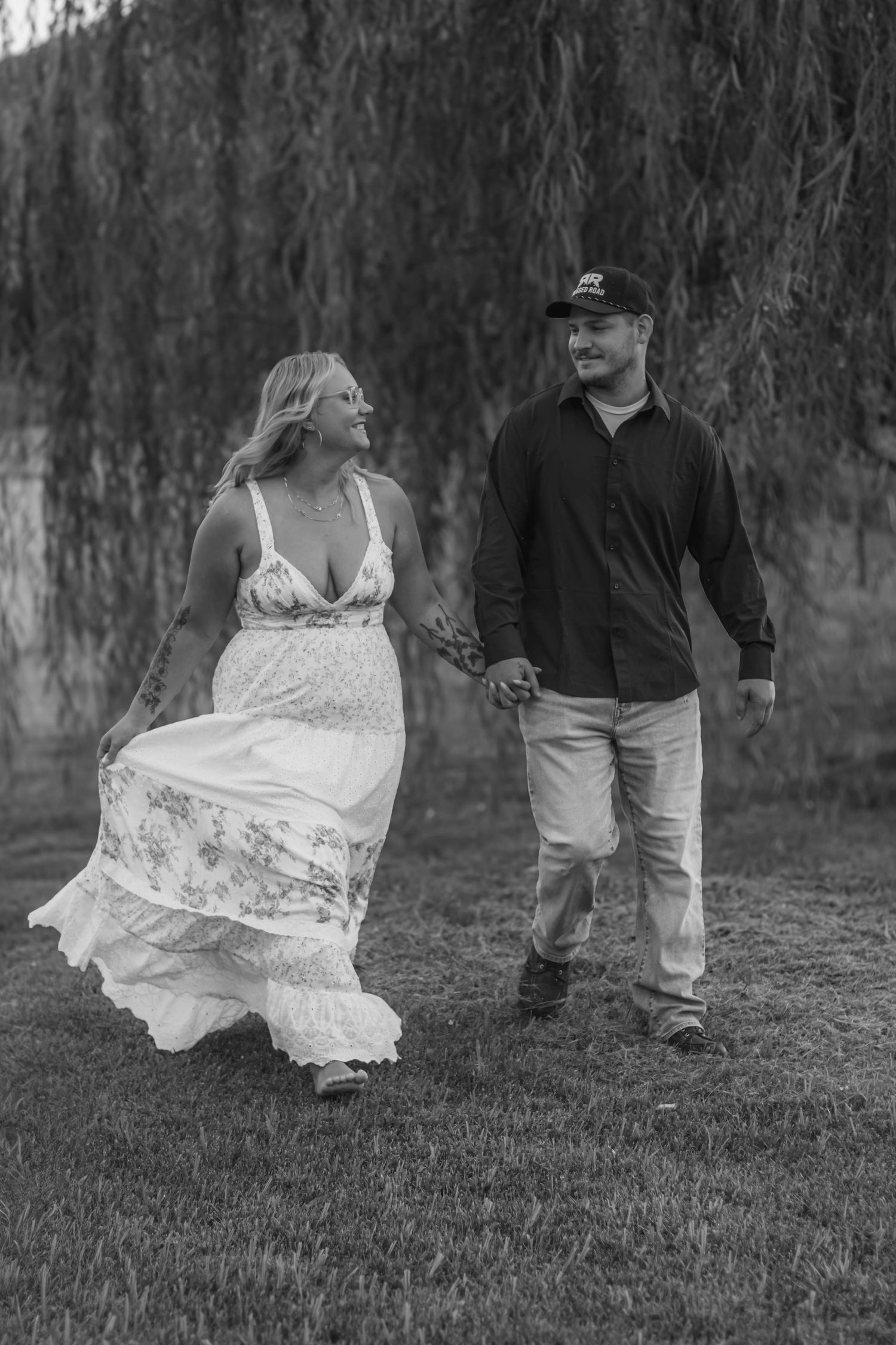 Black-and-white candid of a couple walking together outdoors.