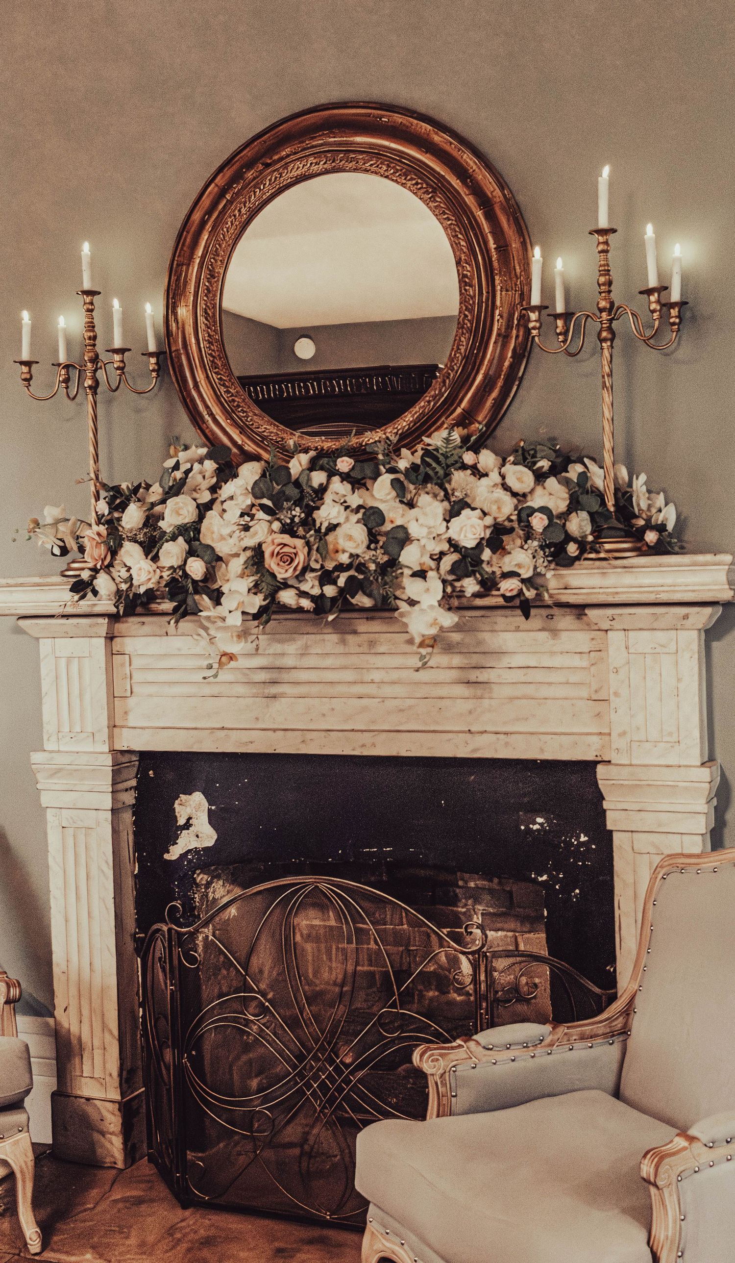 Wedding flowers decorating a vintage fireplace and mirror.