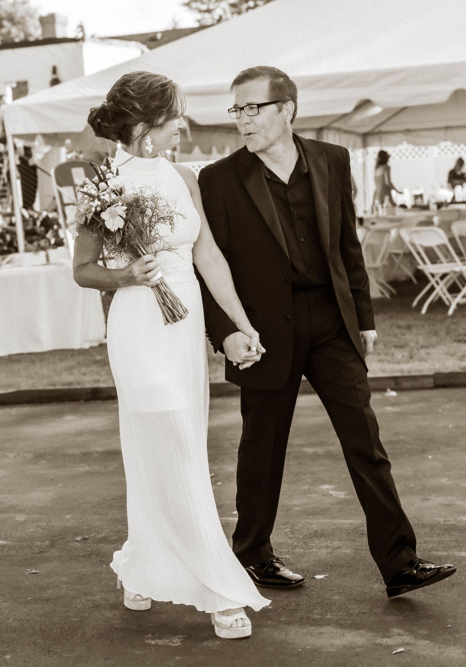 Black-and-white portrait of a bride and groom holding hands