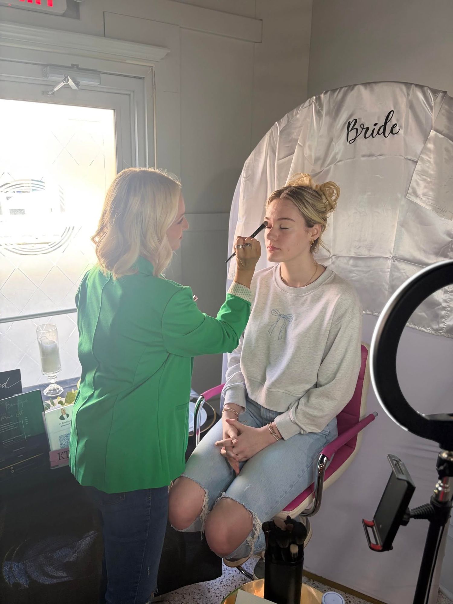 Bridal makeup artist applying makeup to a bride before her wedding