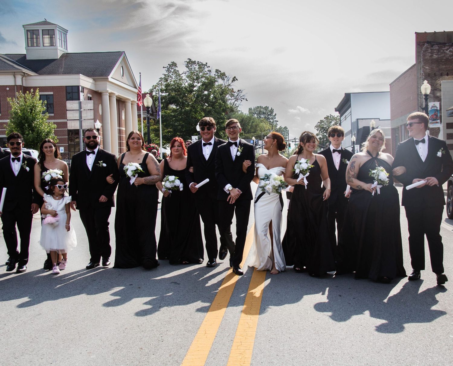 Wedding party walking together down a city street.