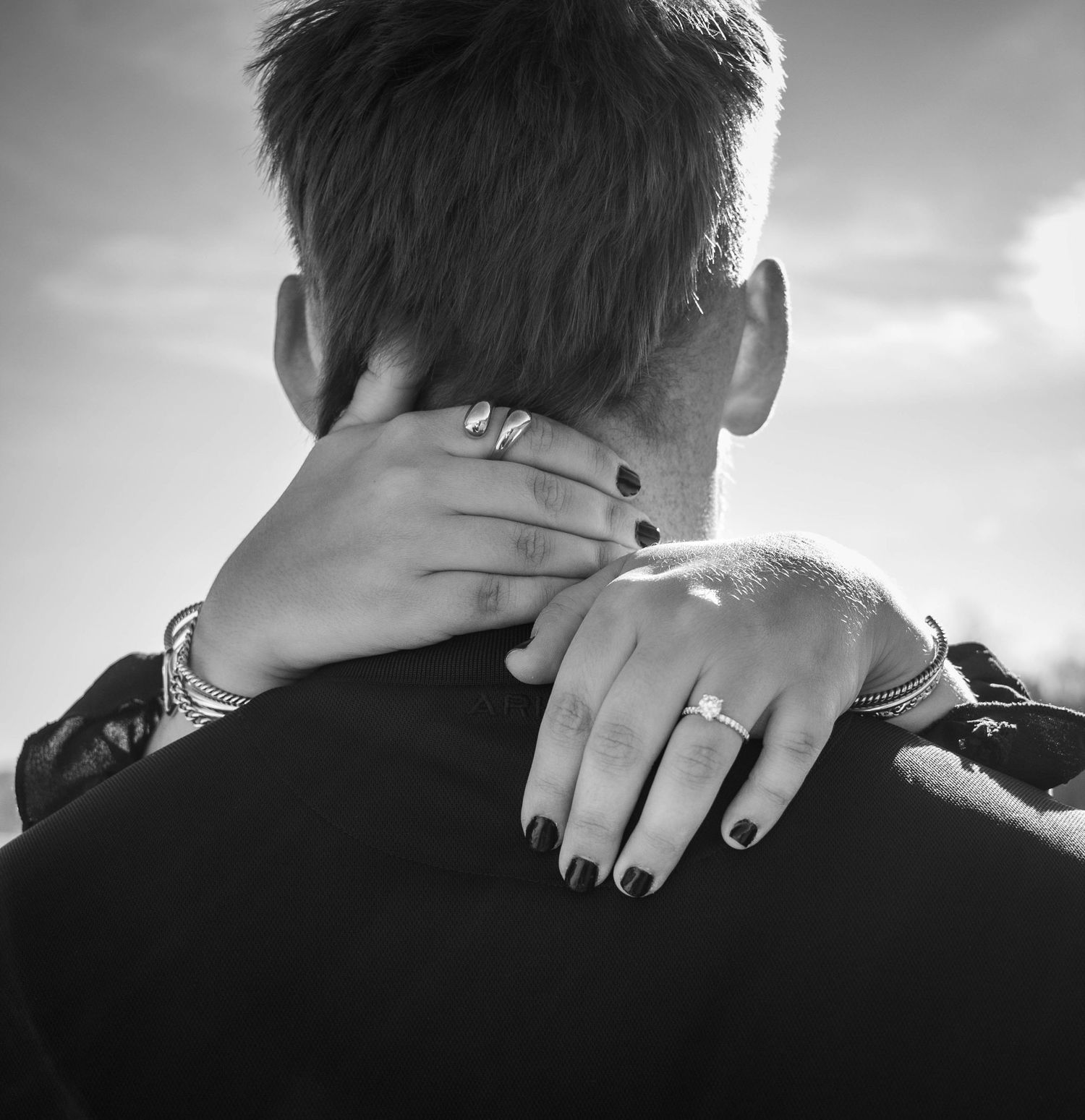 Black-and-white close-up of an engagement ring on a woman’s hand.