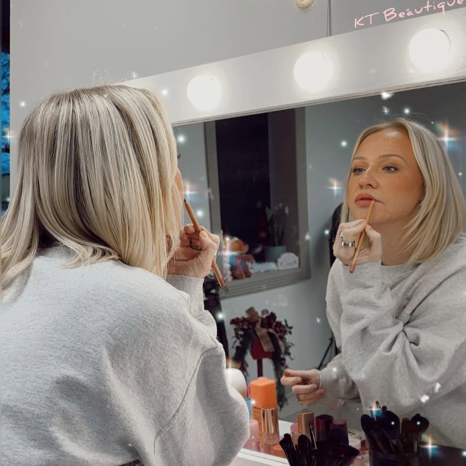 Katie Abell applying makeup at her beauty station for Anna Mae & Co.