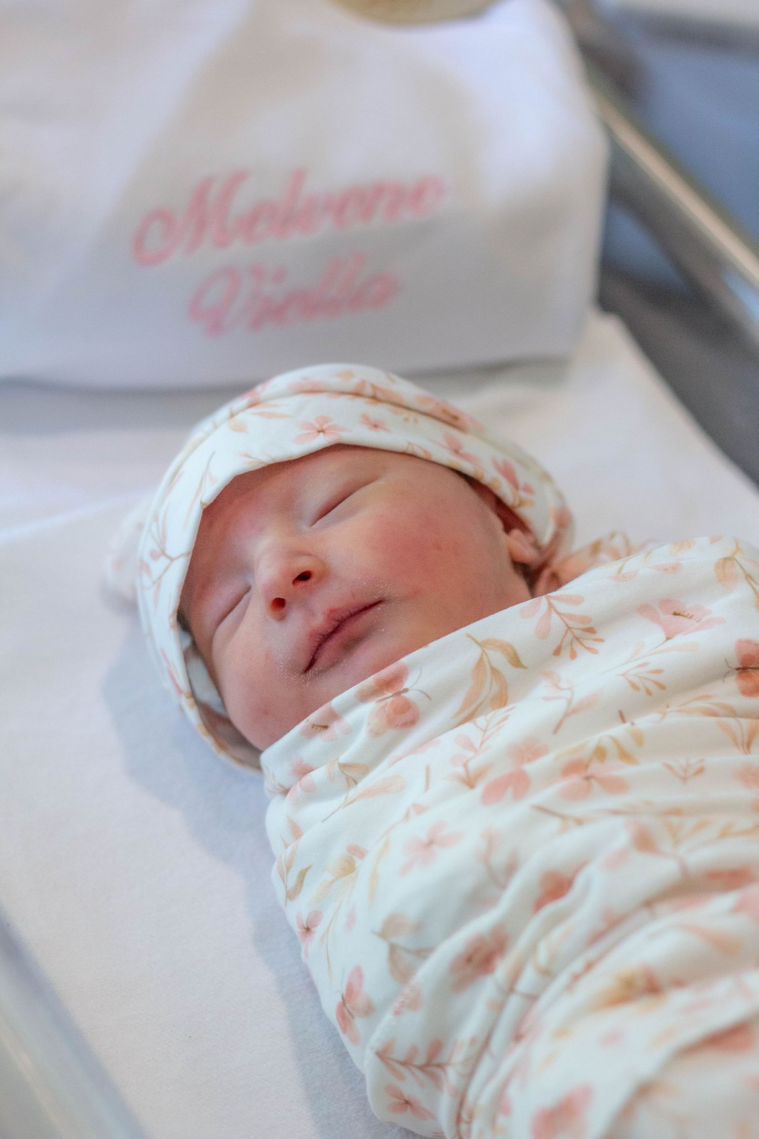 Newborn baby swaddled in a hospital bassinet.