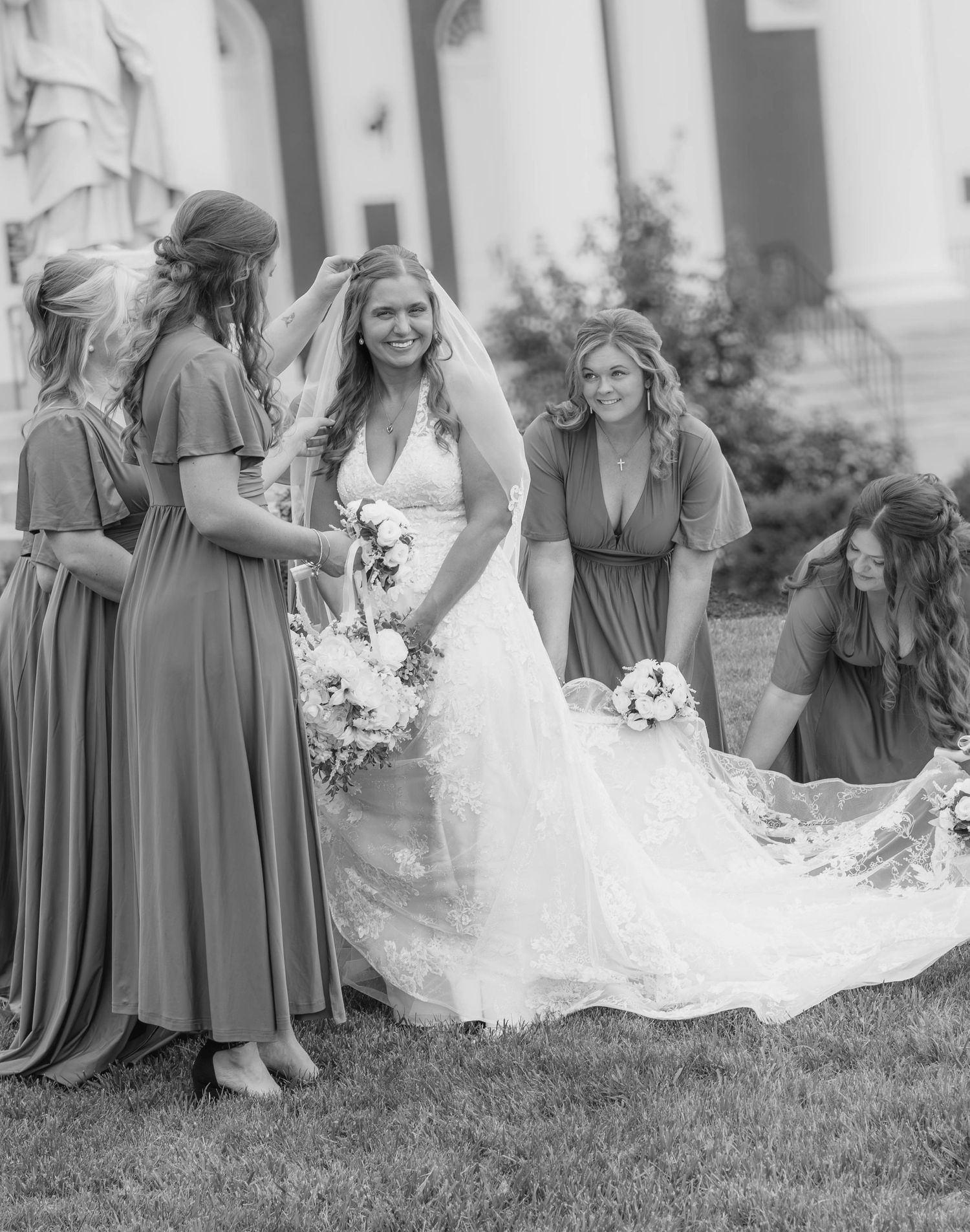 Black-and-white candid of a bride laughing with her bridesmaids.