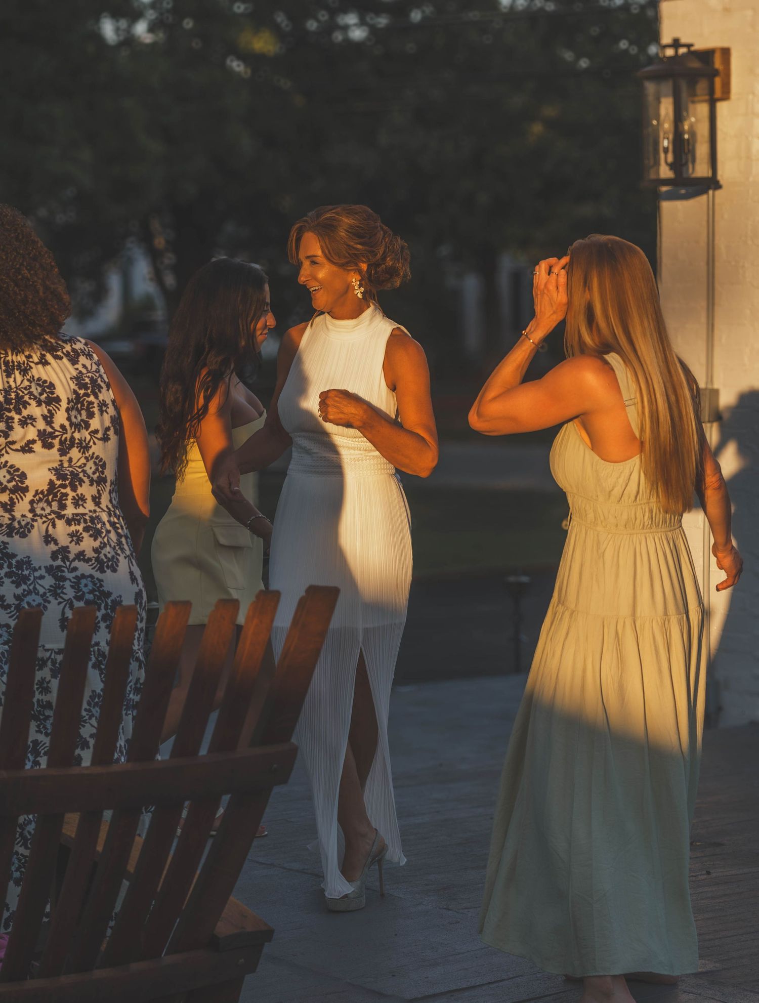 Bride celebrating with friends during a warm sunset wedding moment.