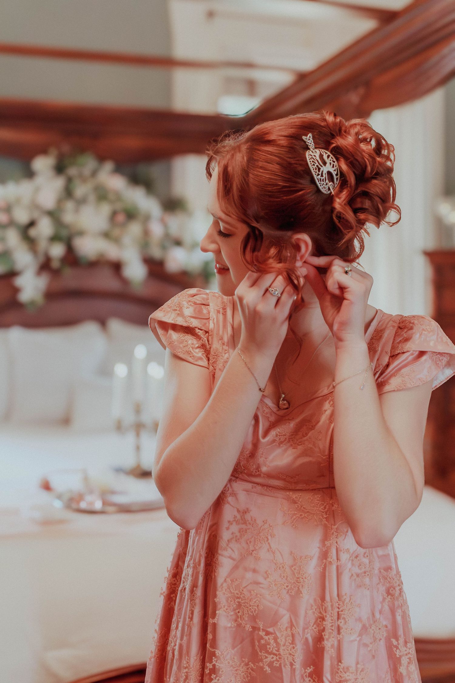 Elegant red bridal updo with decorative hair accessories.