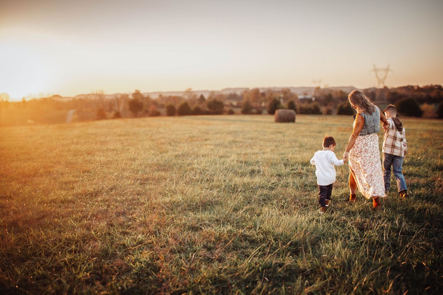 Family walking together through a field at golden hour