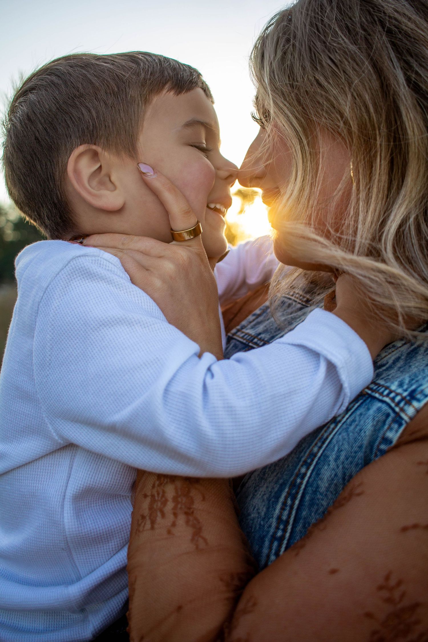 Mother and son sharing a sweet moment with the sunset glowing behind them