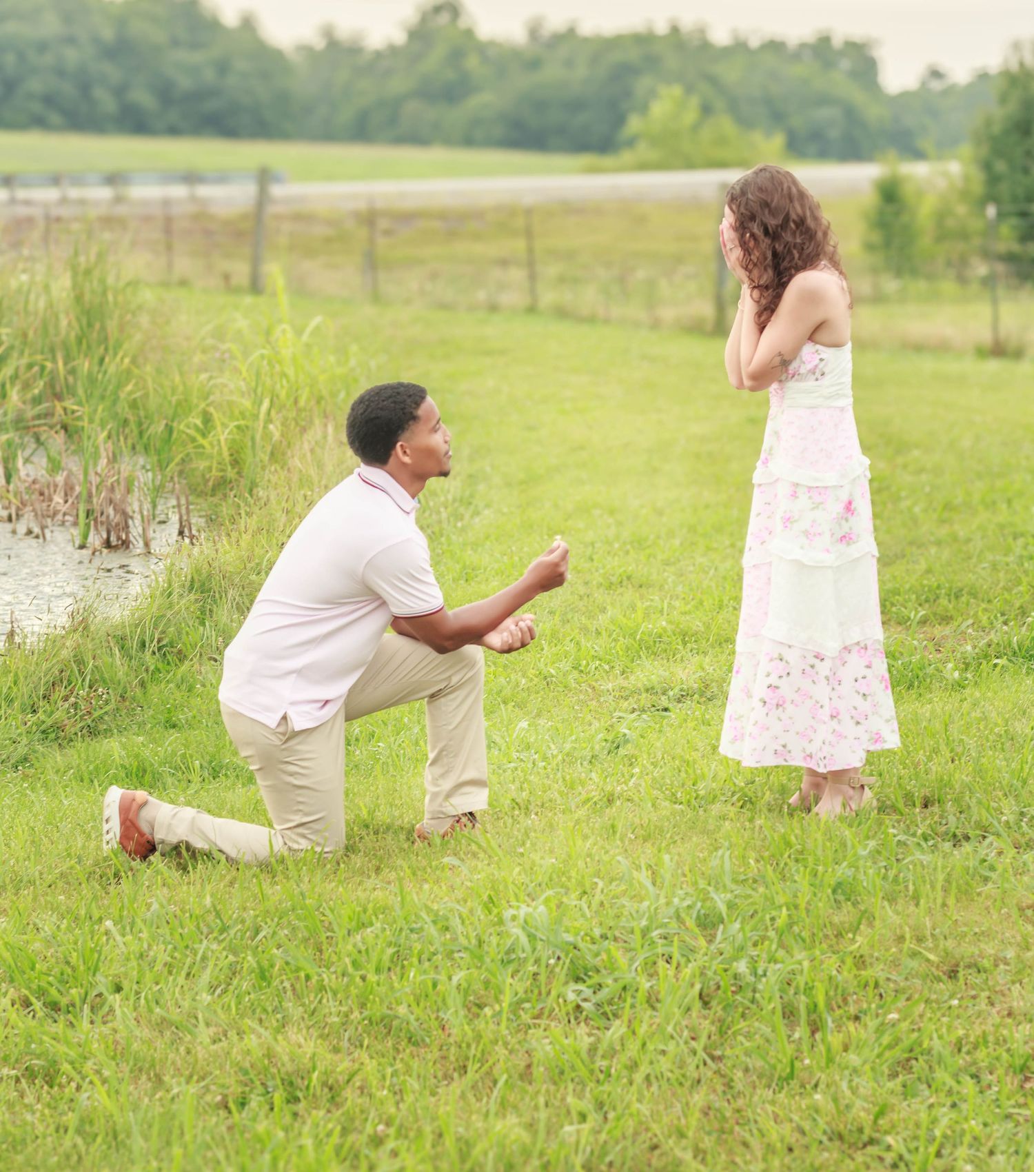 Surprise marriage proposal in a grassy field.