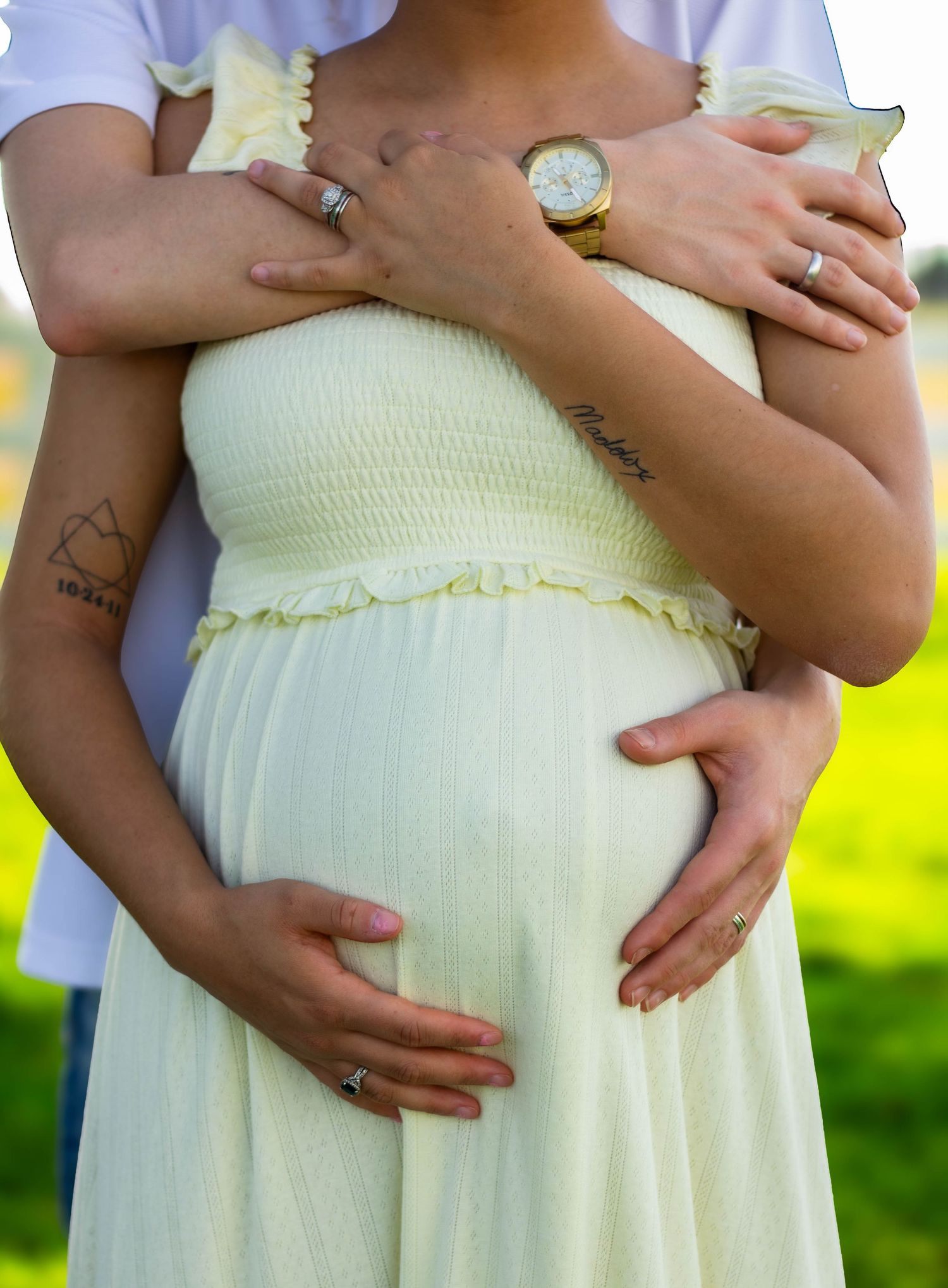 Expectant mother cradling her baby bump during an outdoor maternity session.