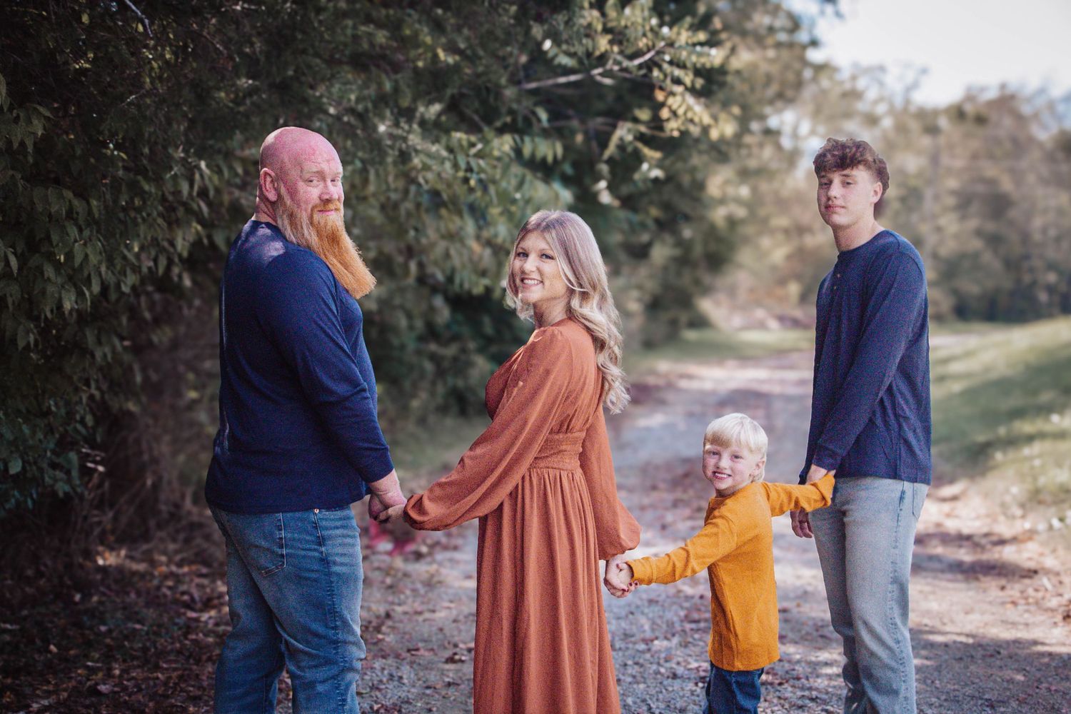 Family of four holding hands together during an outdoor fall session