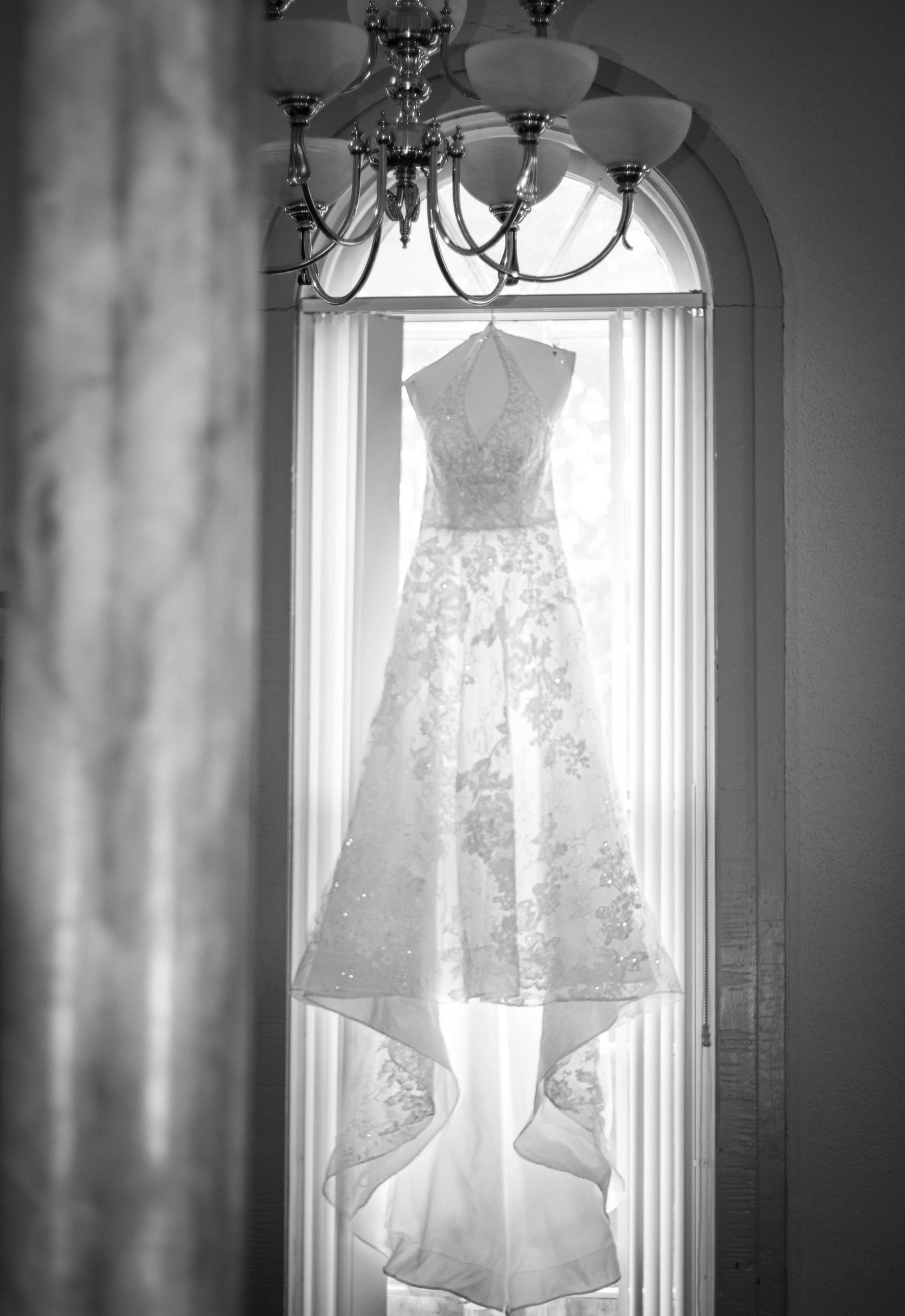 Black-and-white wedding dress hanging in a window.