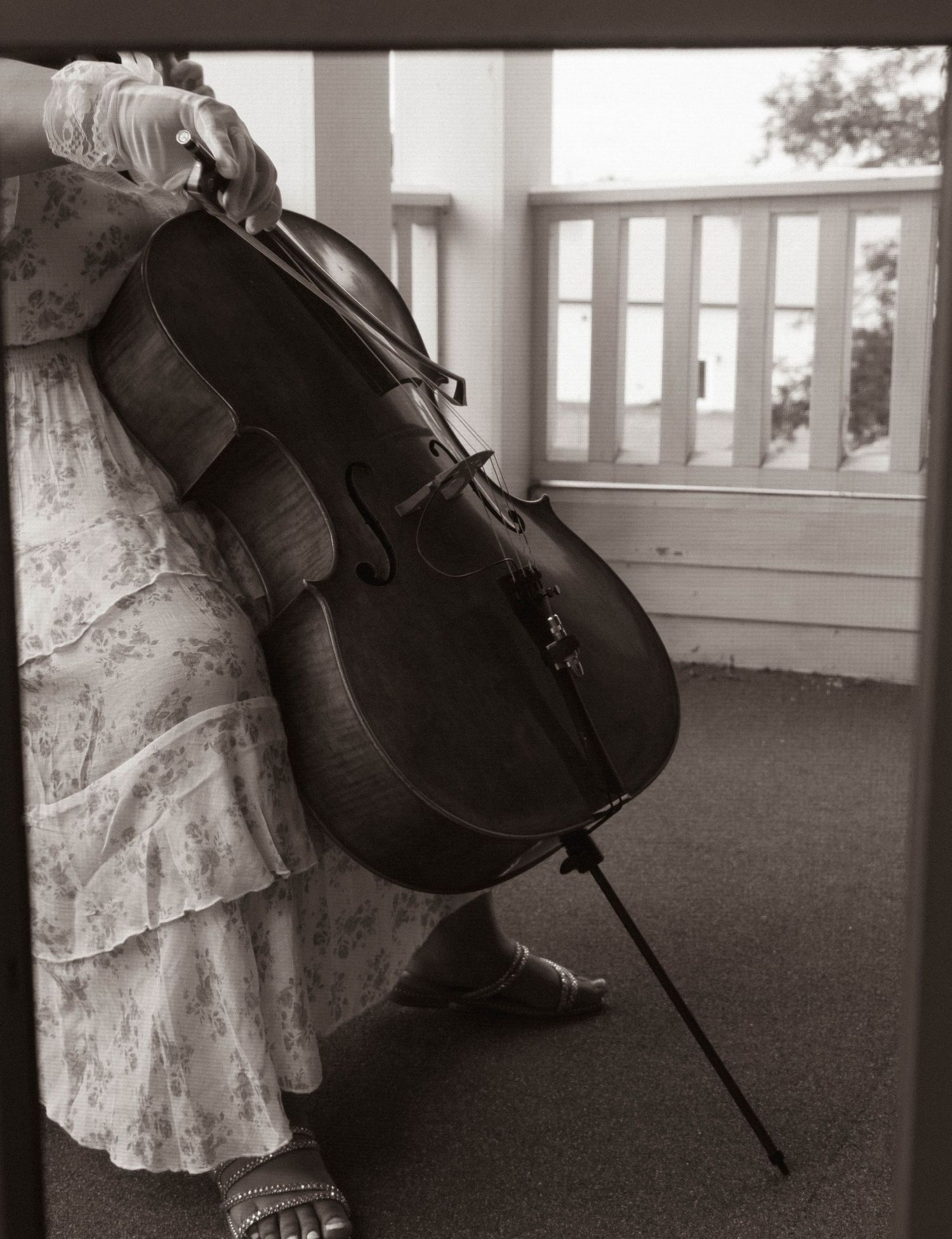Black-and-white photo of a cellist performing during the wedding.