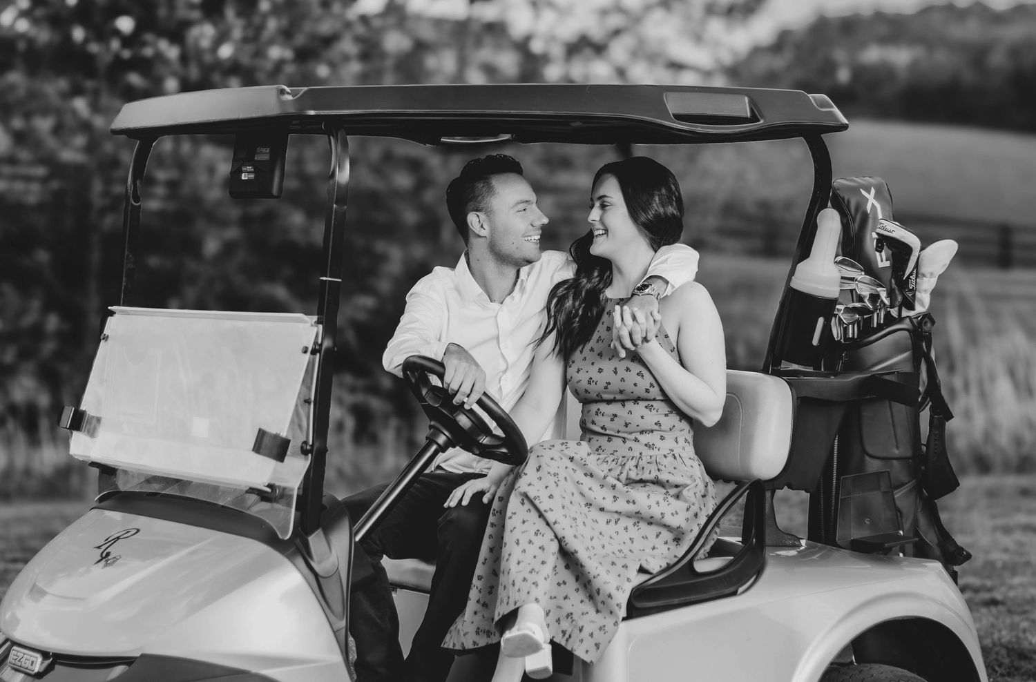Couple sharing a playful moment beside a golf cart.