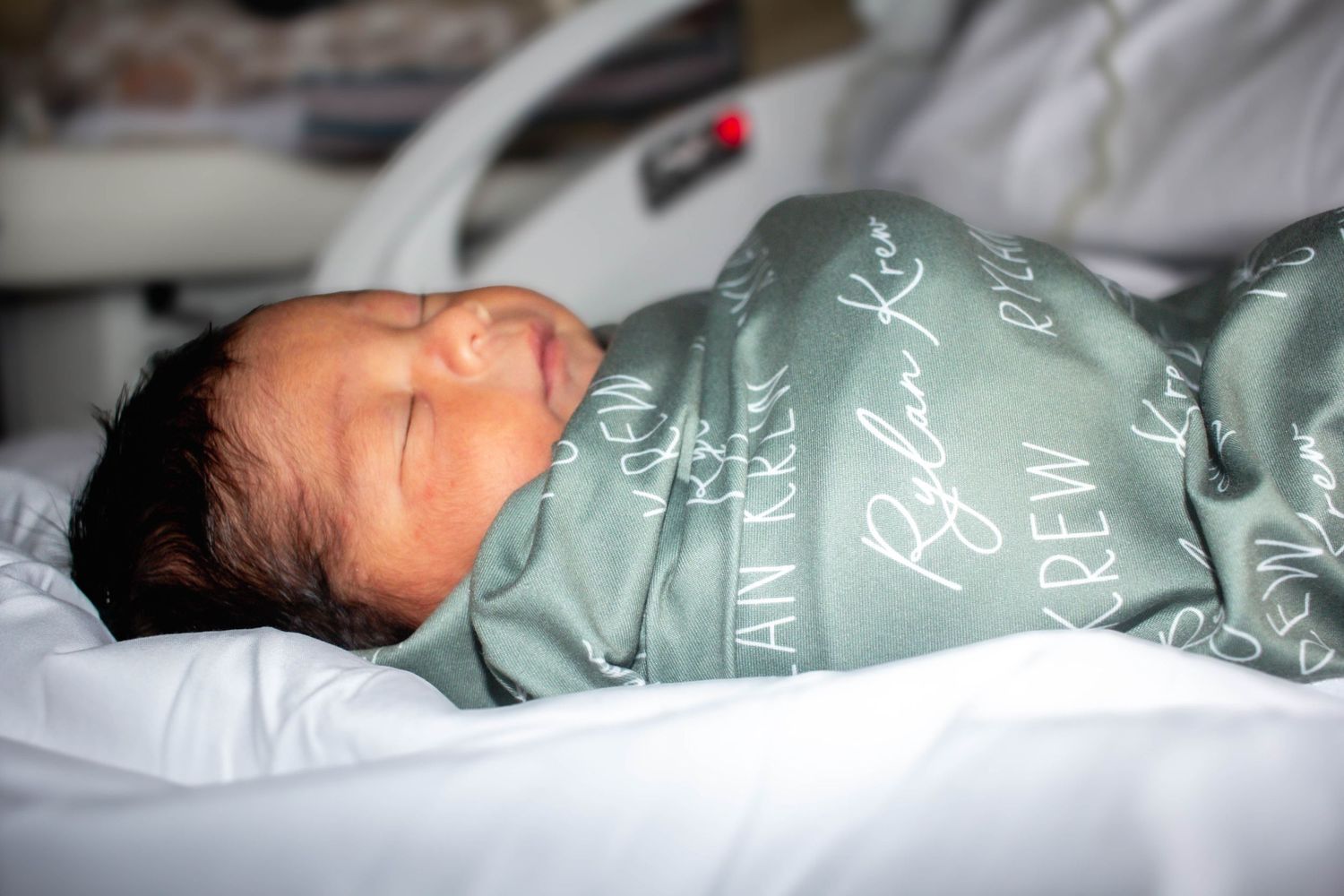 Newborn baby sleeping peacefully in a hospital bassinet.