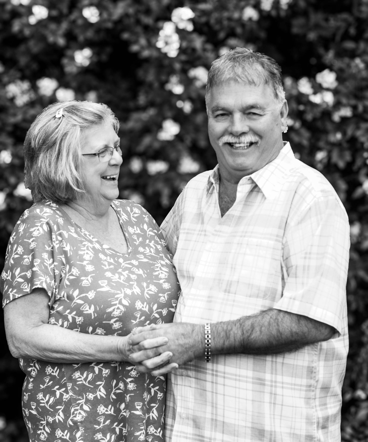 Older couple laughing together in a black-and-white portrait