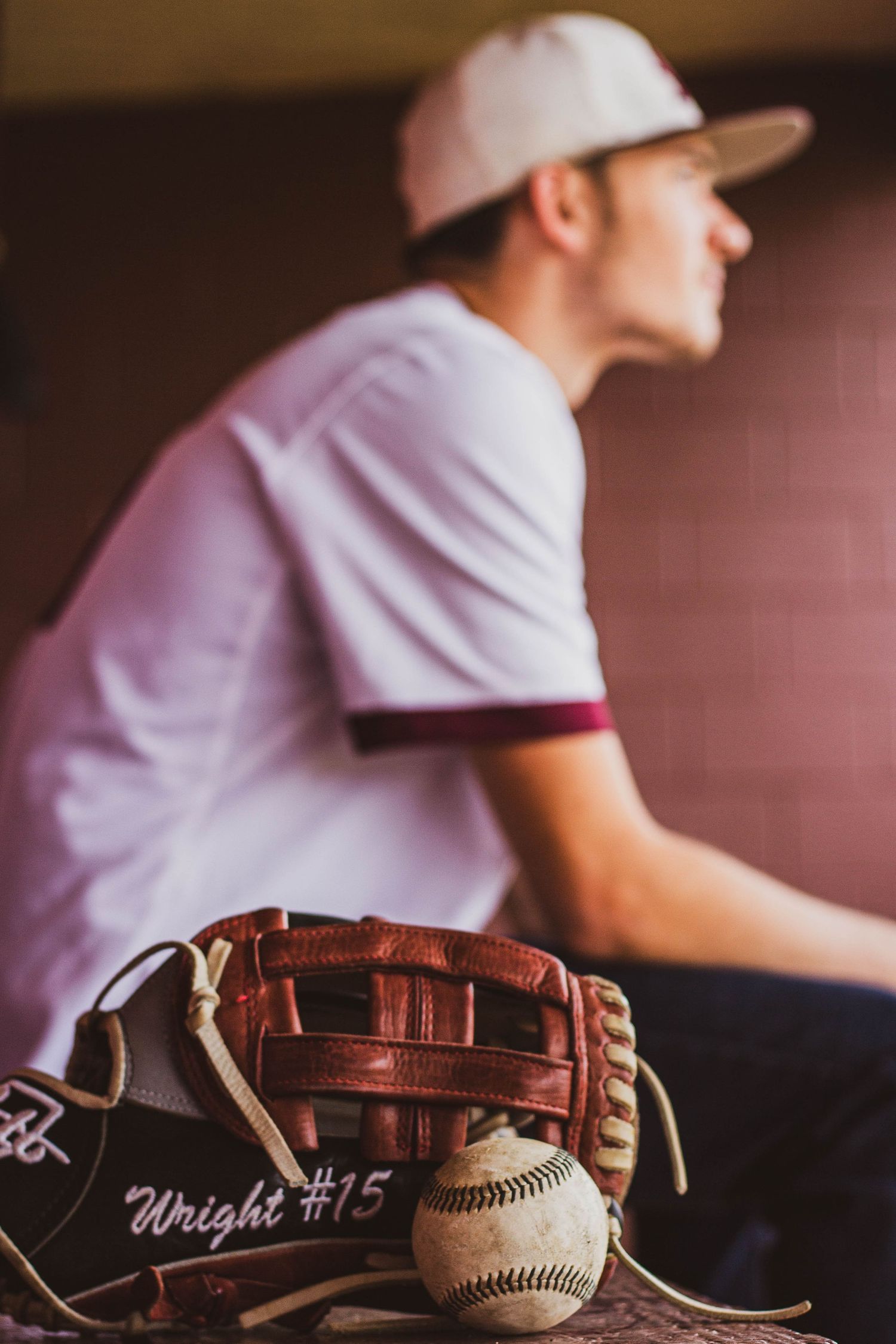 senior boy base ball players glove with last name and ball and senior boy blurred in background