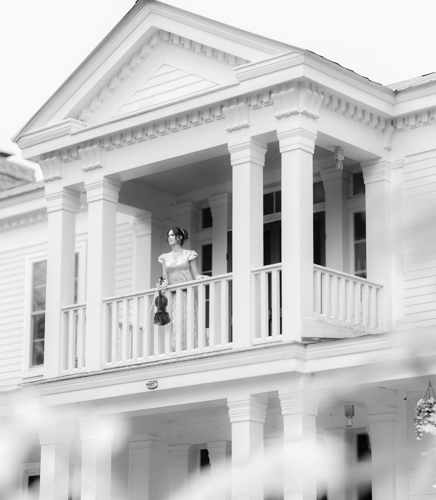 Bride standing on the balcony of an elegant white wedding venue.