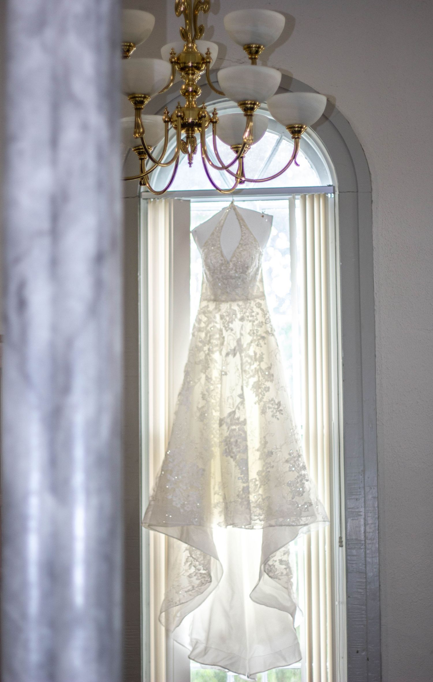 Wedding dress hanging in a window before the ceremony